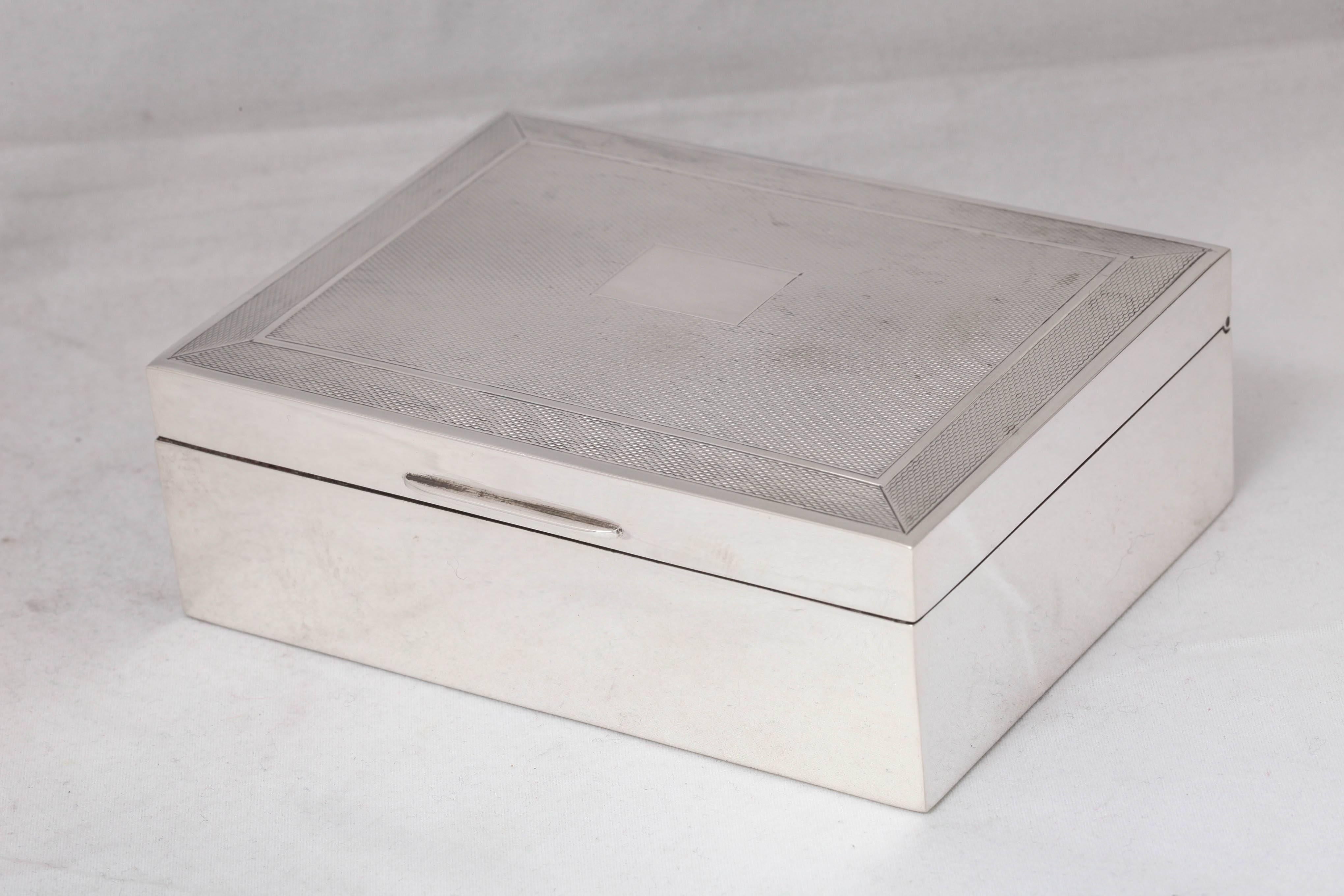 Art Deco, sterling silver table box with hinged lid, Birmingham, England, 1968, John Rose - maker. Engine-turned design on lid; vacant cartouche. Wood lined; leather underside. Measures: 4 3/4