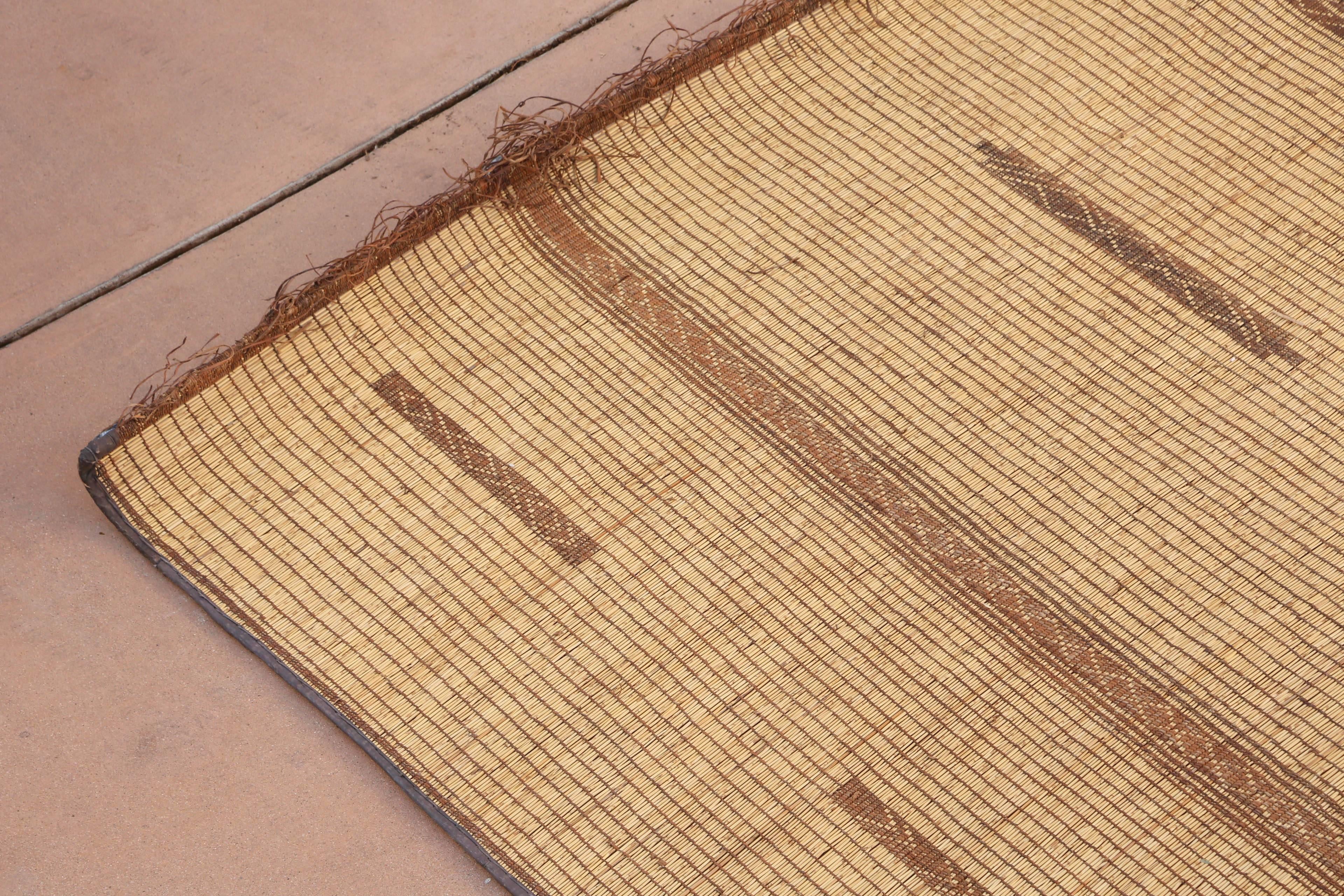 Moroccan Tuareg leather mats are made of dwarf palm tree fibers and hand-woven with leather stripes, this are great to use indoor or outdoor, beautiful brown earth-tone colors. This vintage mid century carpets are made in the desert of Morocco near