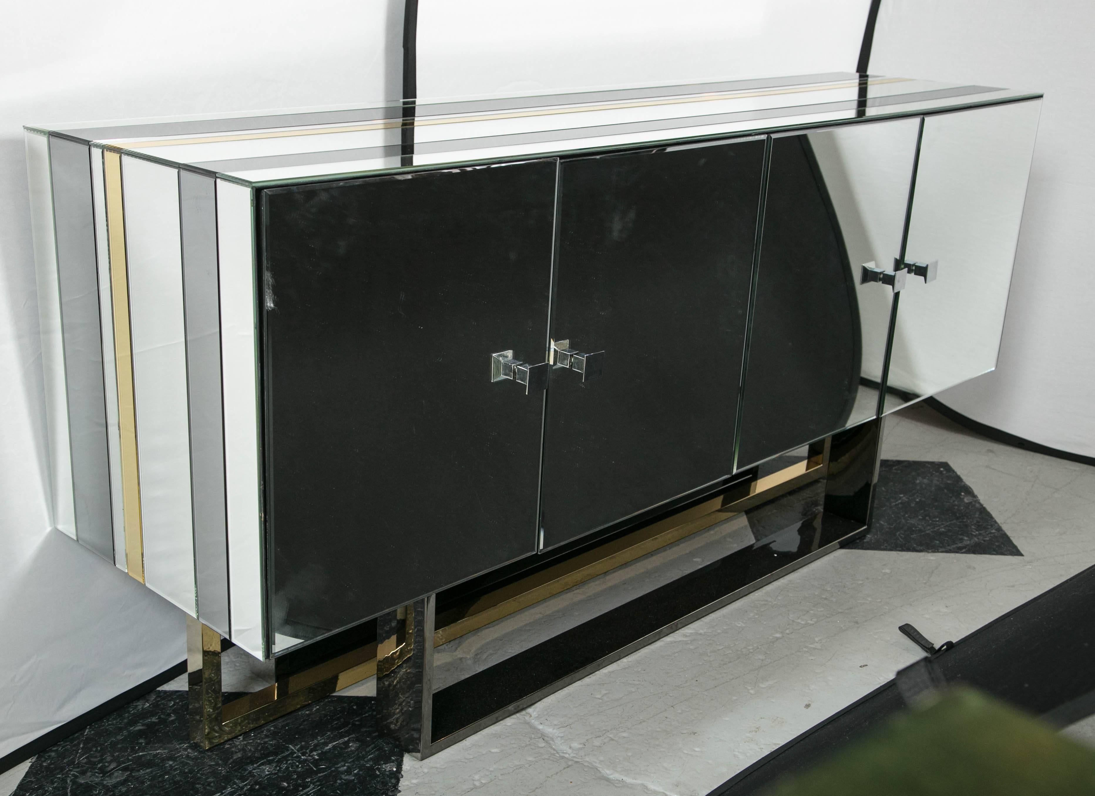 Mid-Century Modern mirrored console cabinet. Millenium buffet table Paul Evans influenced console table having four doors, two cabinet front each fitted with two interior shelves, exterior mirrored surface having gray, clear, and yellow mirrored