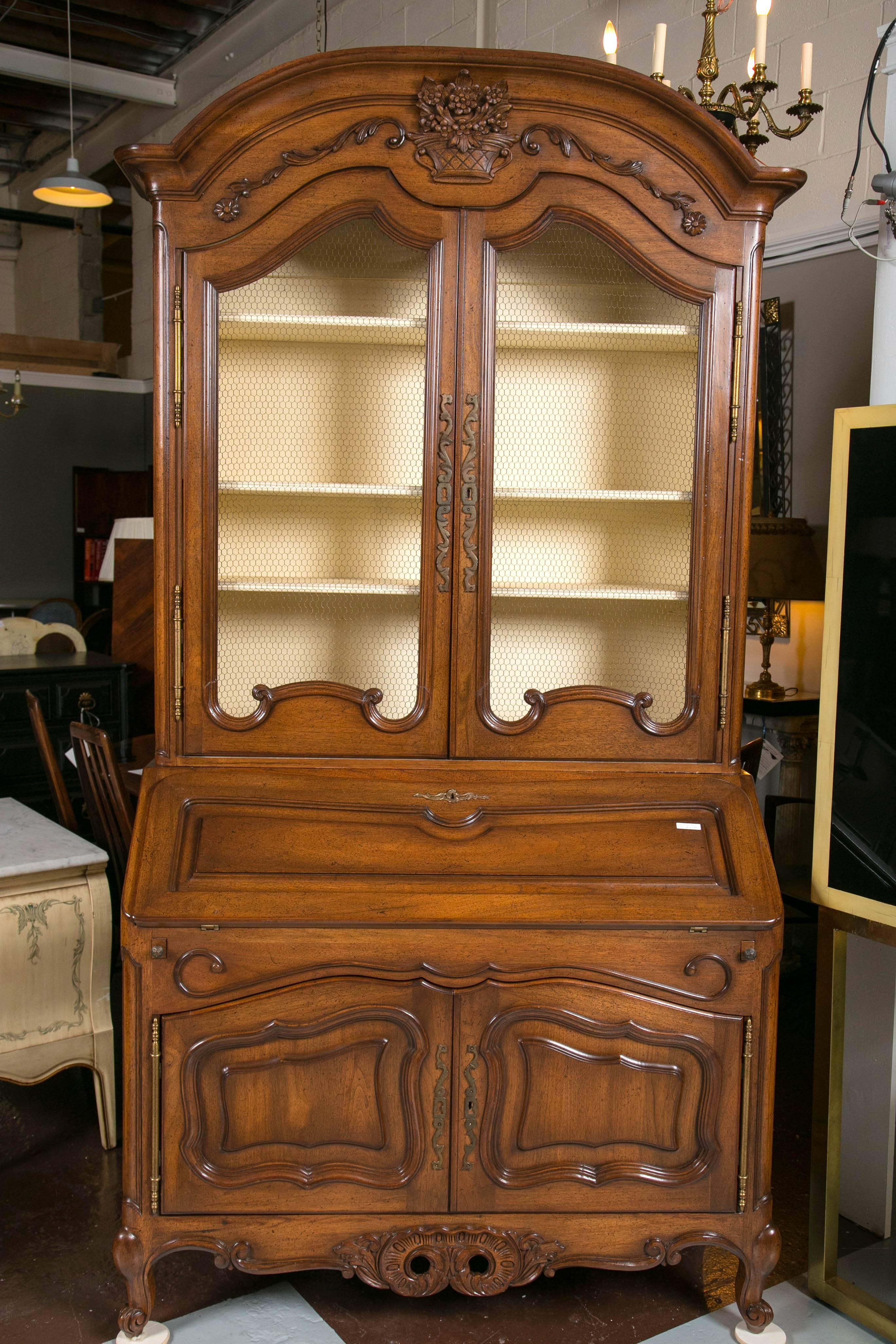 A fabulous French Country breakfront/secretary with cream paint colored interior. This Don Rousseau unsigned piece bears all of the workmanship and detail usually seen in a custom quality piece by this highly sought after cabinetmaker. Fabulous old