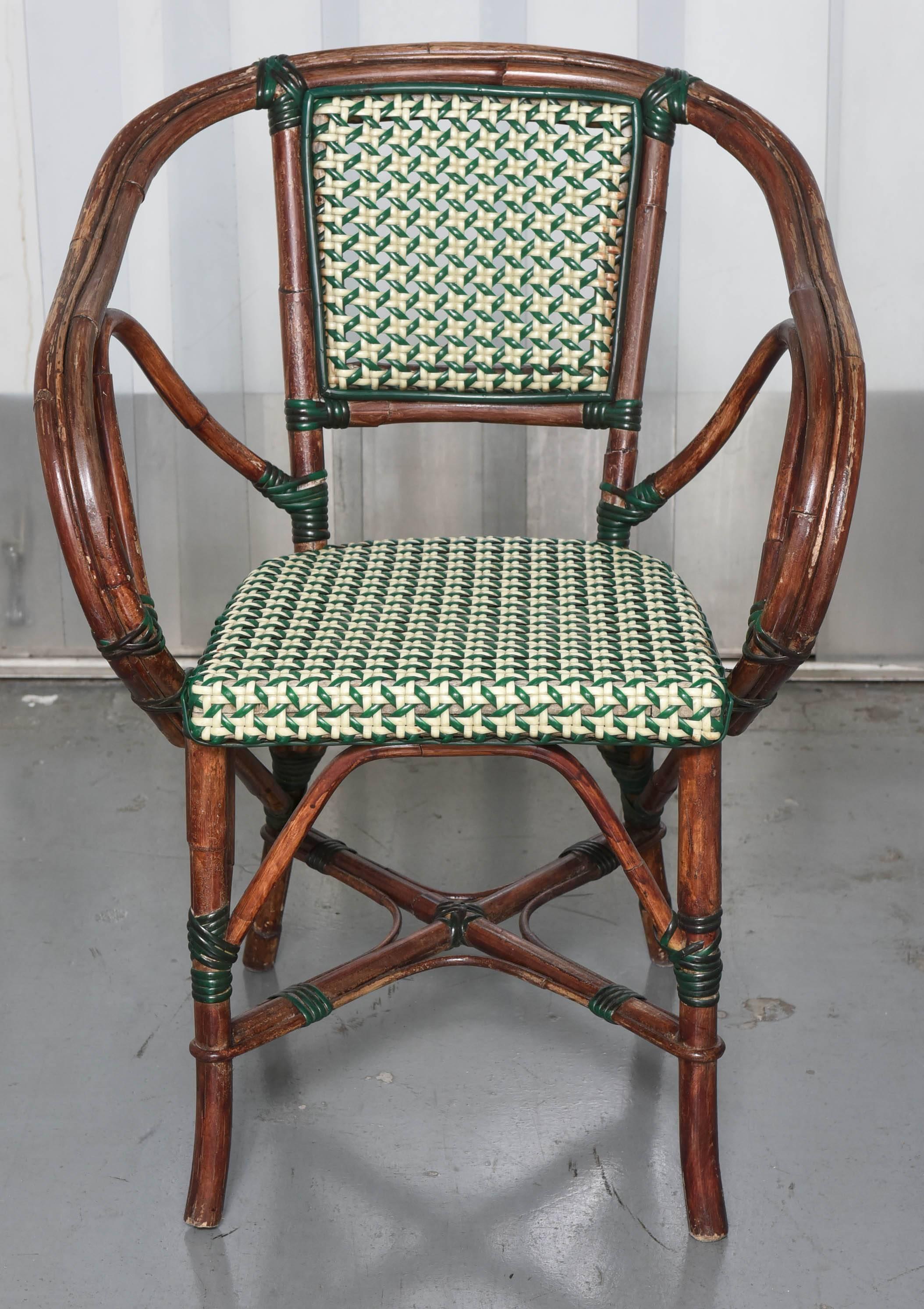 Three French Pairs of bamboo cafe chairs with green and white plastics seats and back seats.