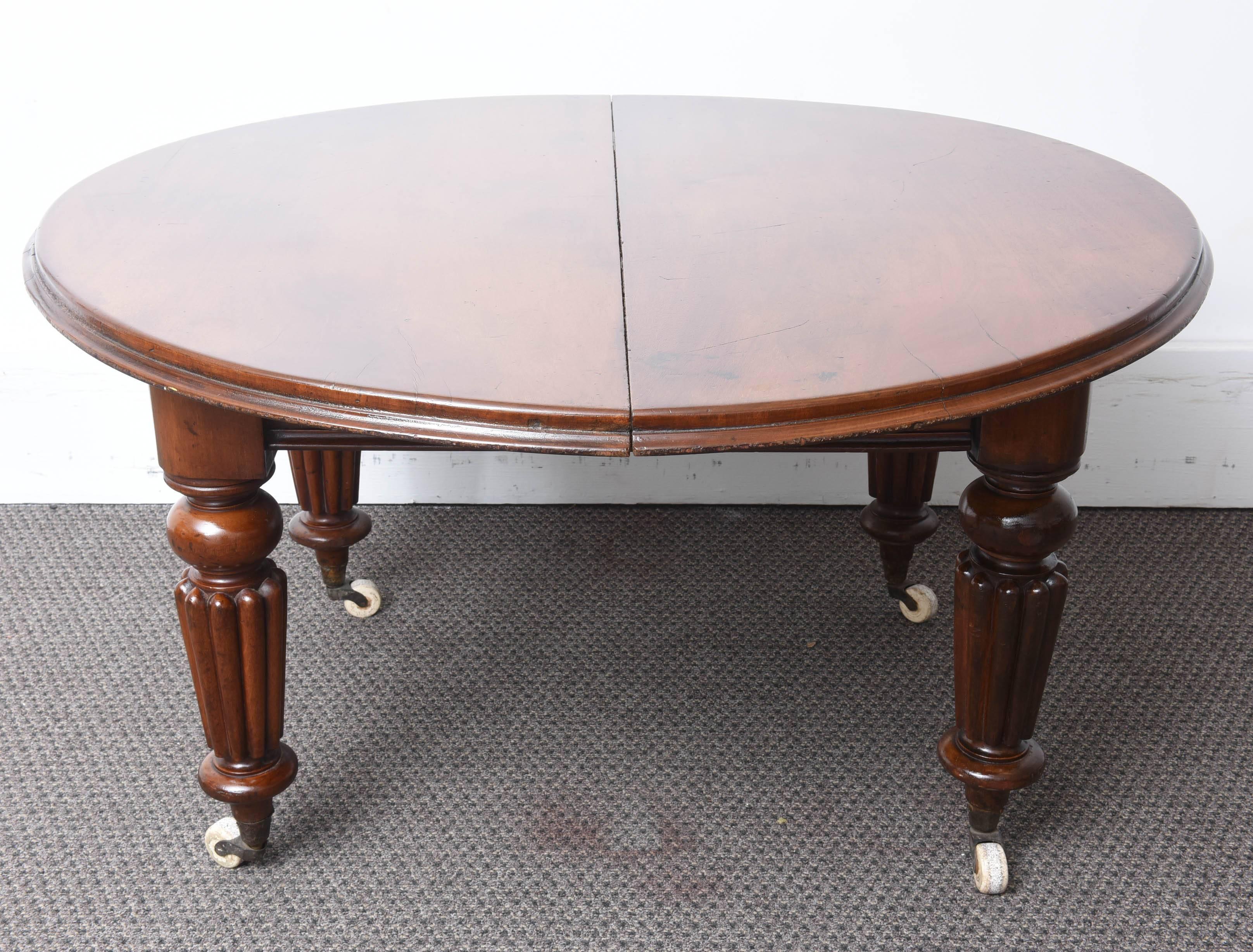 This is a very nice original round dining table in mahogany and extends with three leafs to the center.
It sits on turned fluted legs and has the original brass and ceramic castors.
I would say two of the leafs are original and the other one was