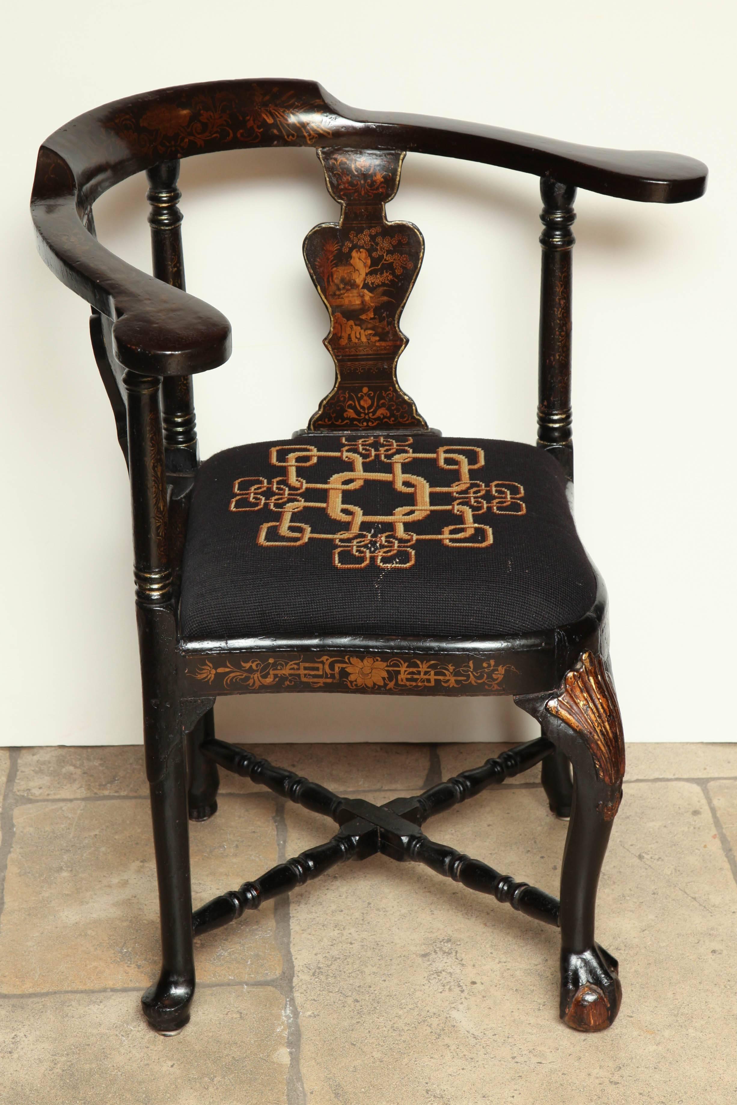 An unusual Queen Anne lacquered and chinoiserie decorated corner chair with urn form splats, compass seat, carved shell cabriole leg, stretcher base and ball and claw carved foot.