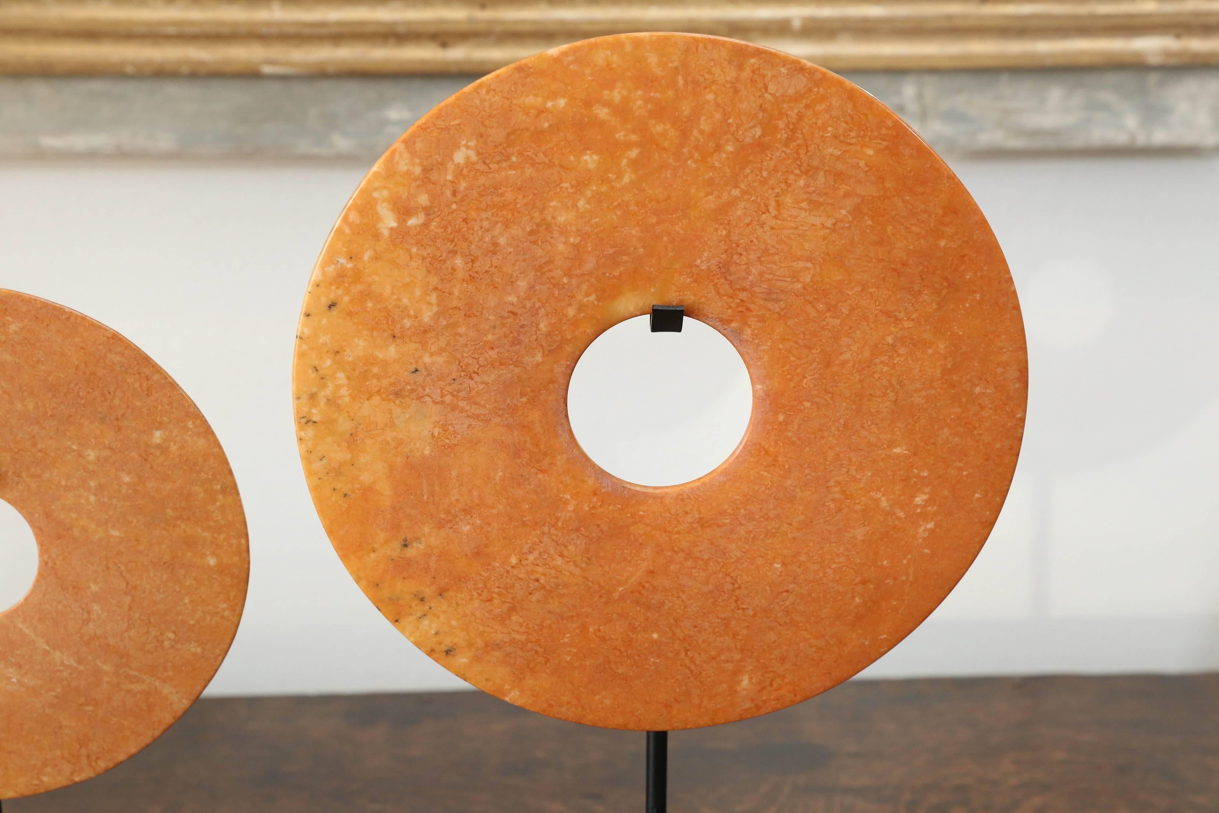 
This is a set of three Bi Chinese stone flat disks with a hole in the centre on iron stands. The Bi disk was a symbol of heaven or of the sun. It was commonly used by nobles as a ceremonial utensil during sacrifices to the gods and to ancestors,