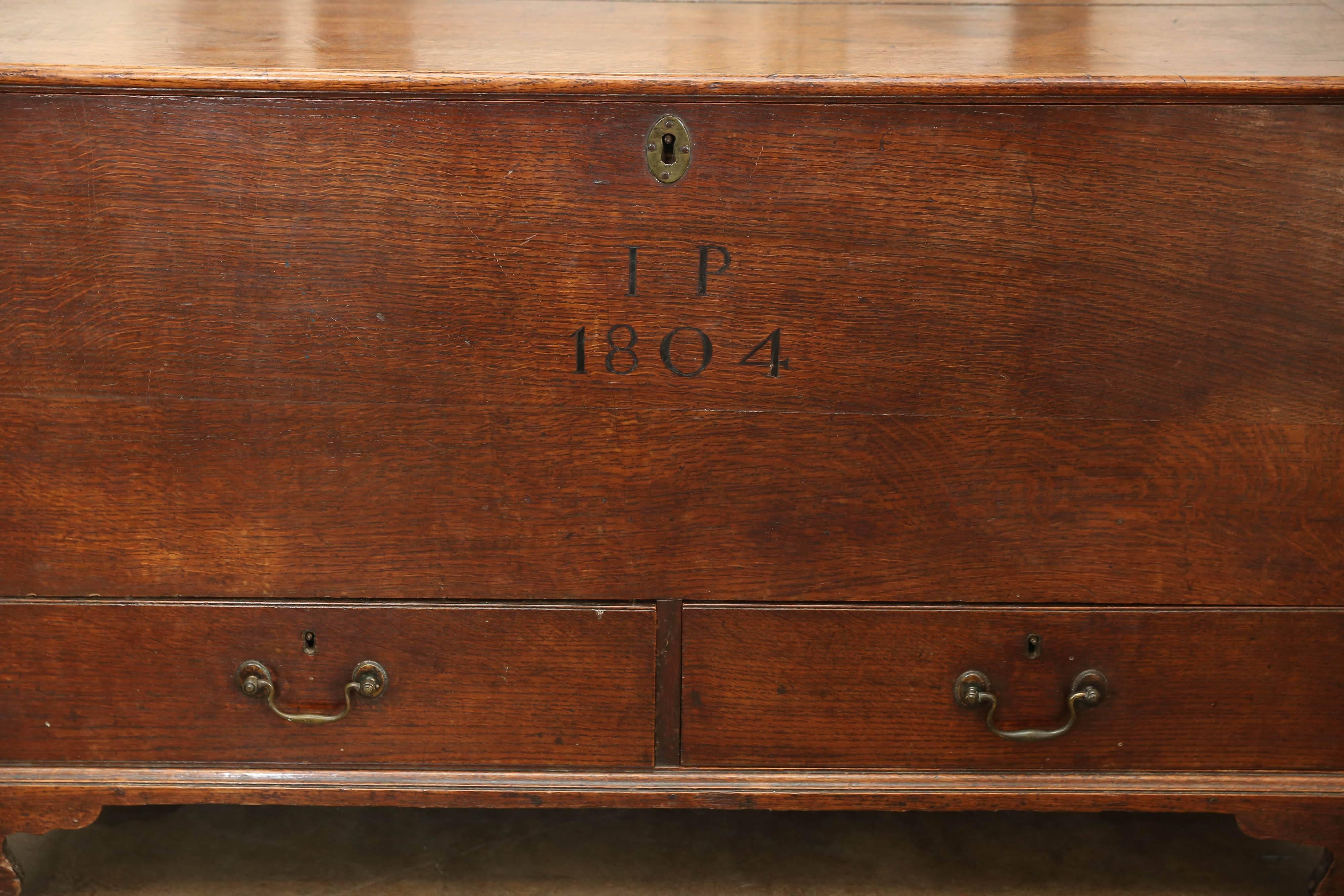 19th century chest on bracket feet with a top that opens to reveal storage and drawers below. Painted are the initials I.P. and the date, 1804. Beautiful patina.