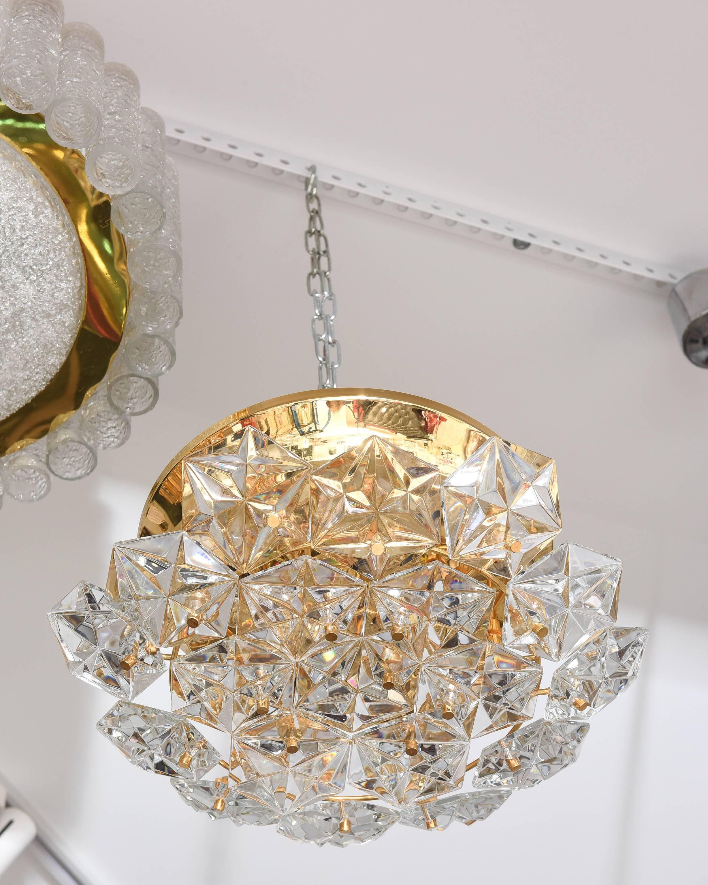 This beautiful chandelier definitely has the glamorous Hollywood-Regency style to it with its gold plated hardware and Northern Star motif polygon shaped prisms.  It was created in the 1970s by the iconic firm of Kinkeldey..

Note:  This piece