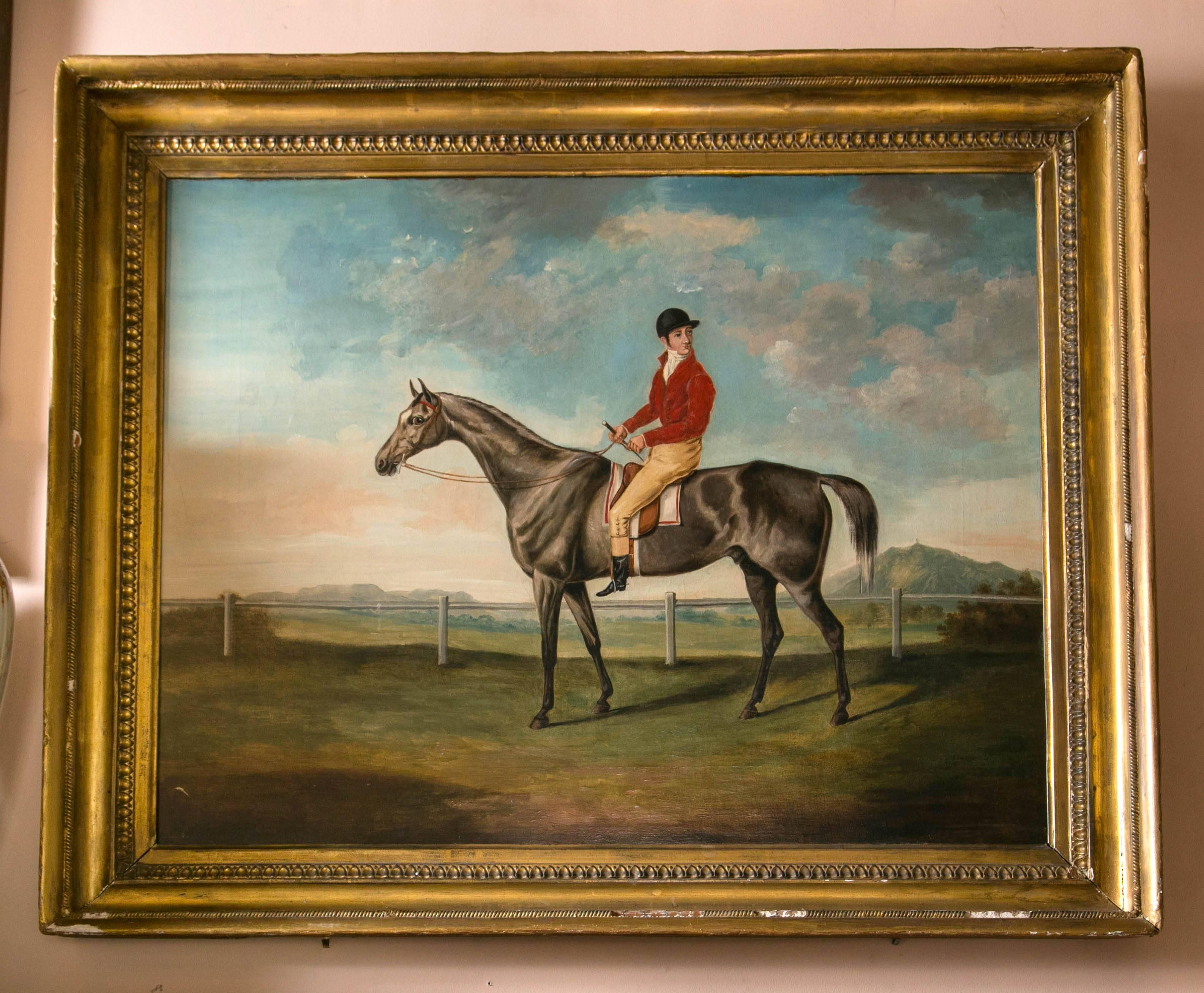 Dating from the second half of the 19th century, from England, with its period frame. The horse has a beautiful shimmering silver, grey coat. The jockey looking over his left shoulder. Set in a fenced area with blue skies and clouds.
The frame