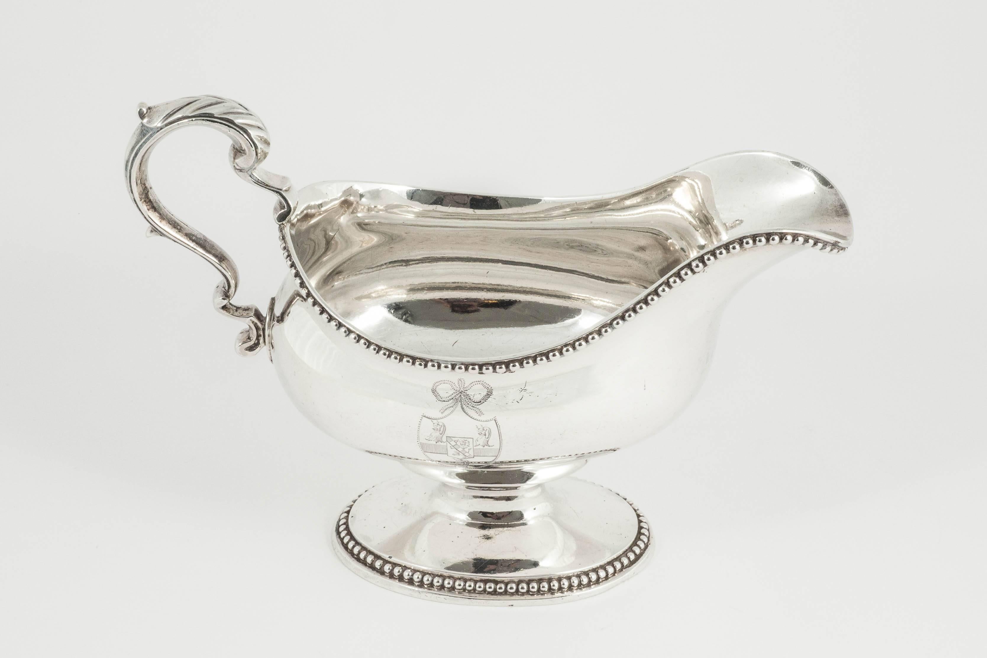 A superb pair of heavy quality sterling silver Georgian sauce boats or gravy boats with bead pattern mounts. Each boat is on a cast oval foot which gives a wonderful substantial feel to these pieces, and the bellied bodies are engraved on one side