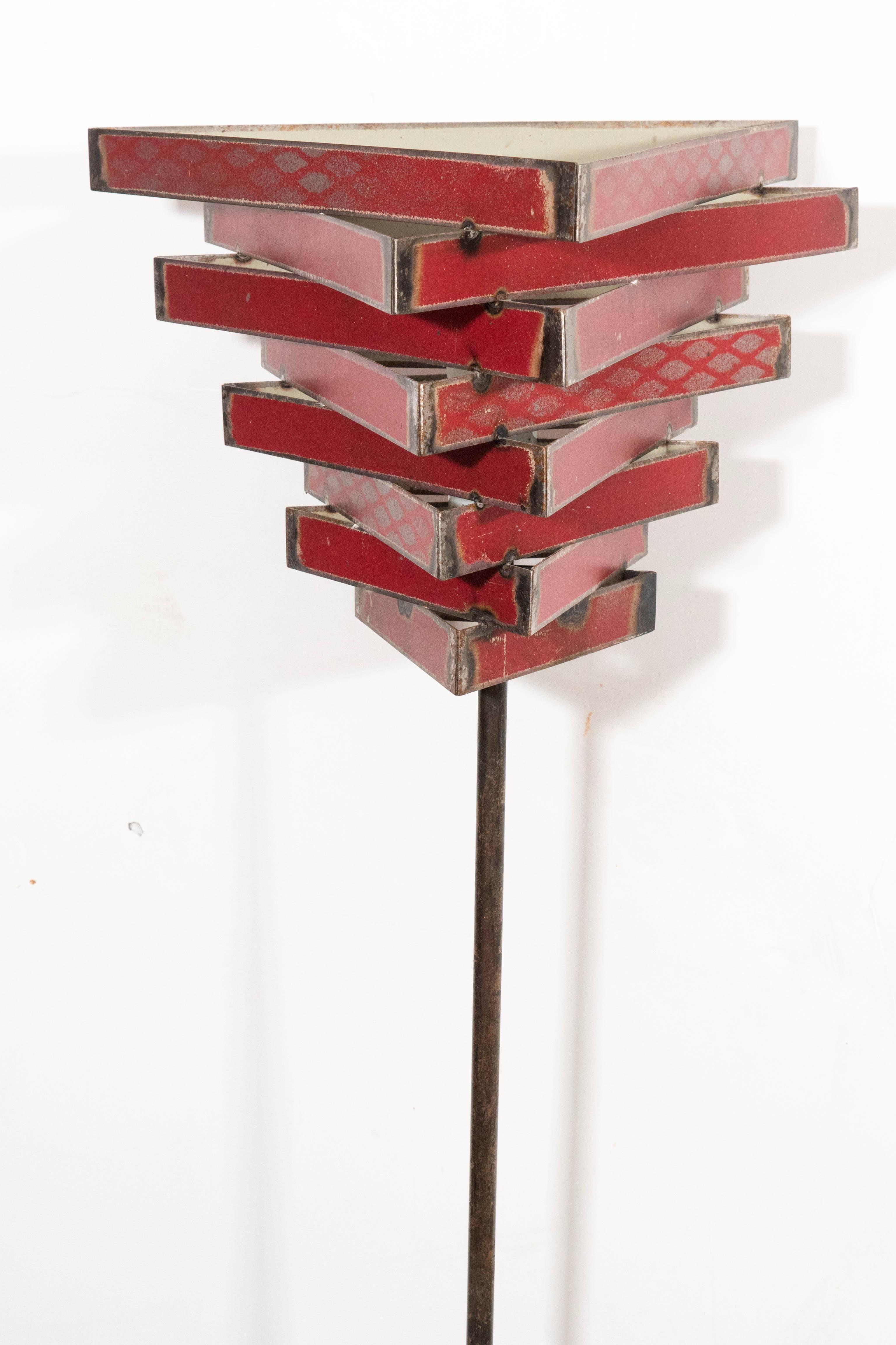 Eight tiered decorative torchiere shade with alternate red motifs. Heavy metal base and metal stand.