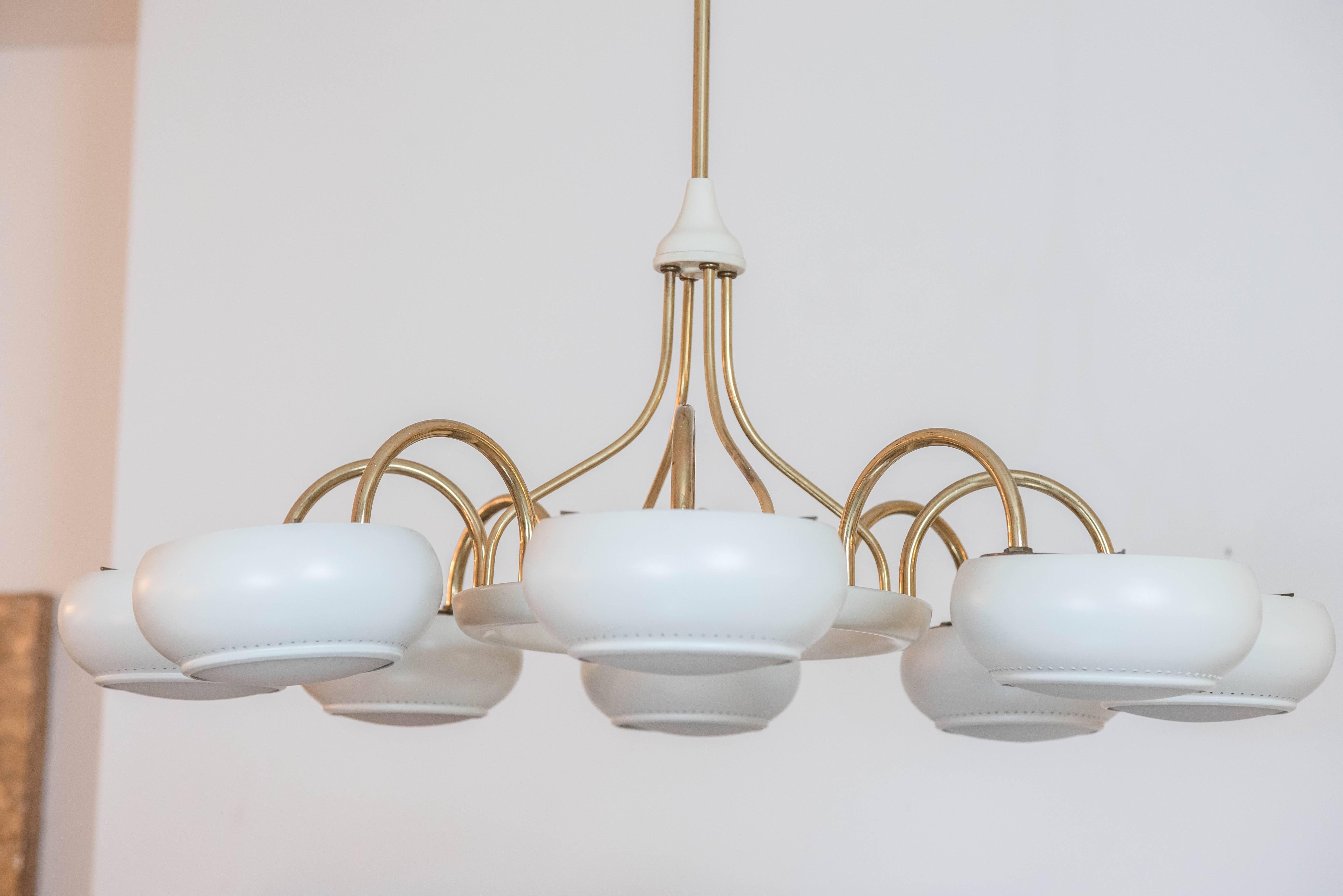 An elegant brass and white painted light fixture after prominent designer Paavo Tynell. The light is in good working order with original perforated glass shades.