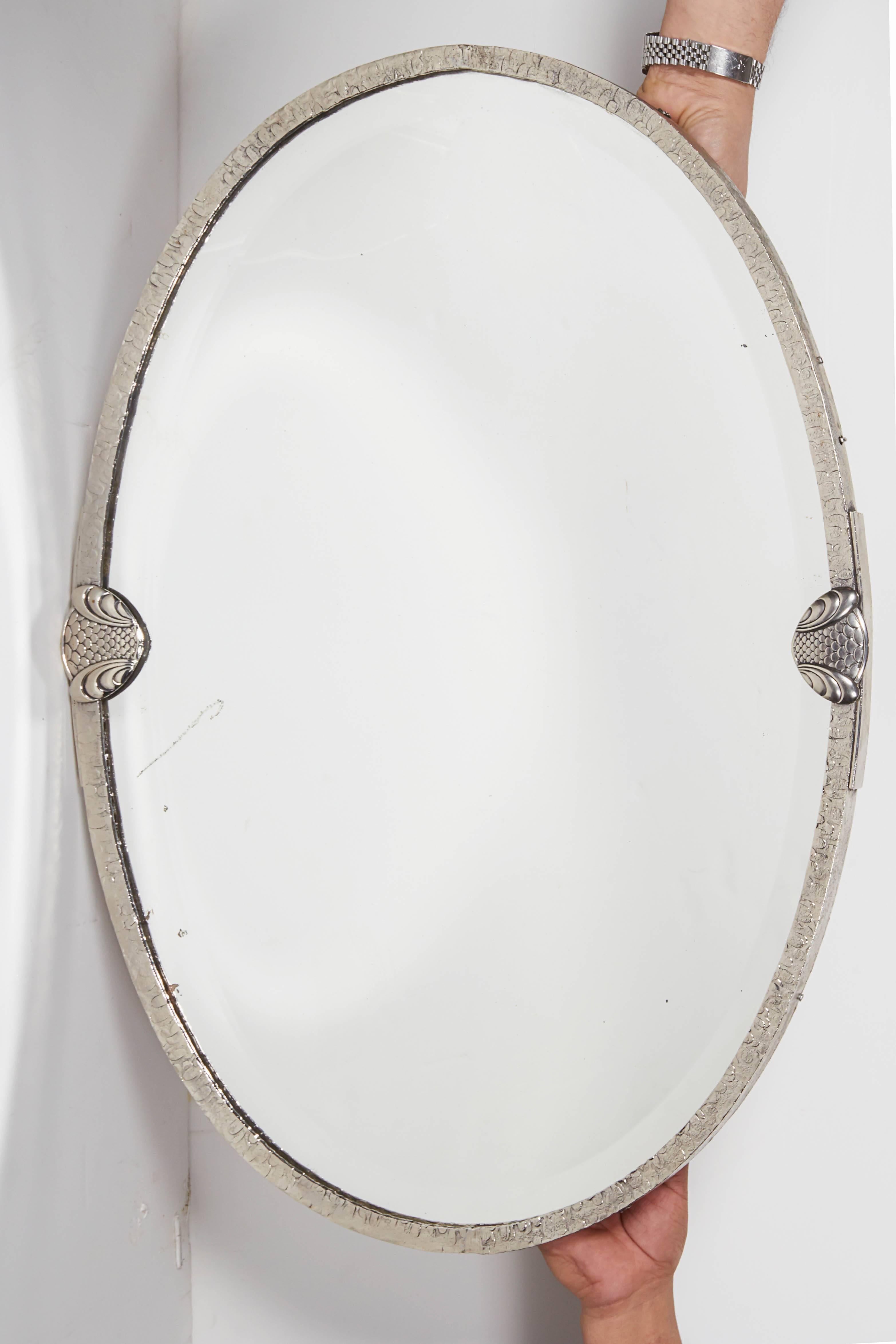 French Modernist oval mirror in hand forged nickeled iron with decorative clips flanking sides and beveled mirror inset.
The mirror can be adjusted to hang either horizontally or vertically.
Modernist, Art Deco, Italian design, mid century,over