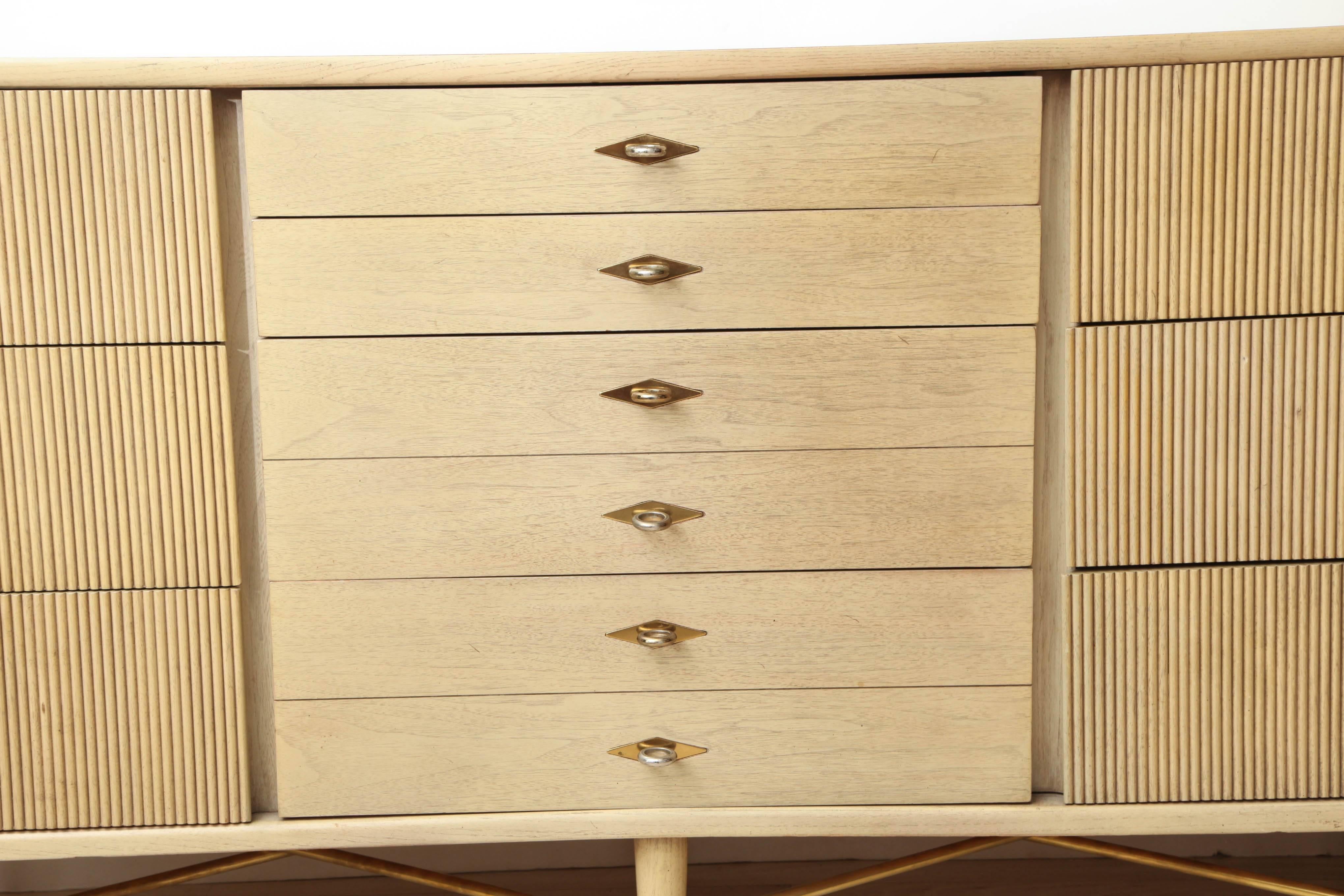 Blond oak commode/buffet with three sections, the center section with six narrow drawers flanked by two sections with three wide ribbed drawers.