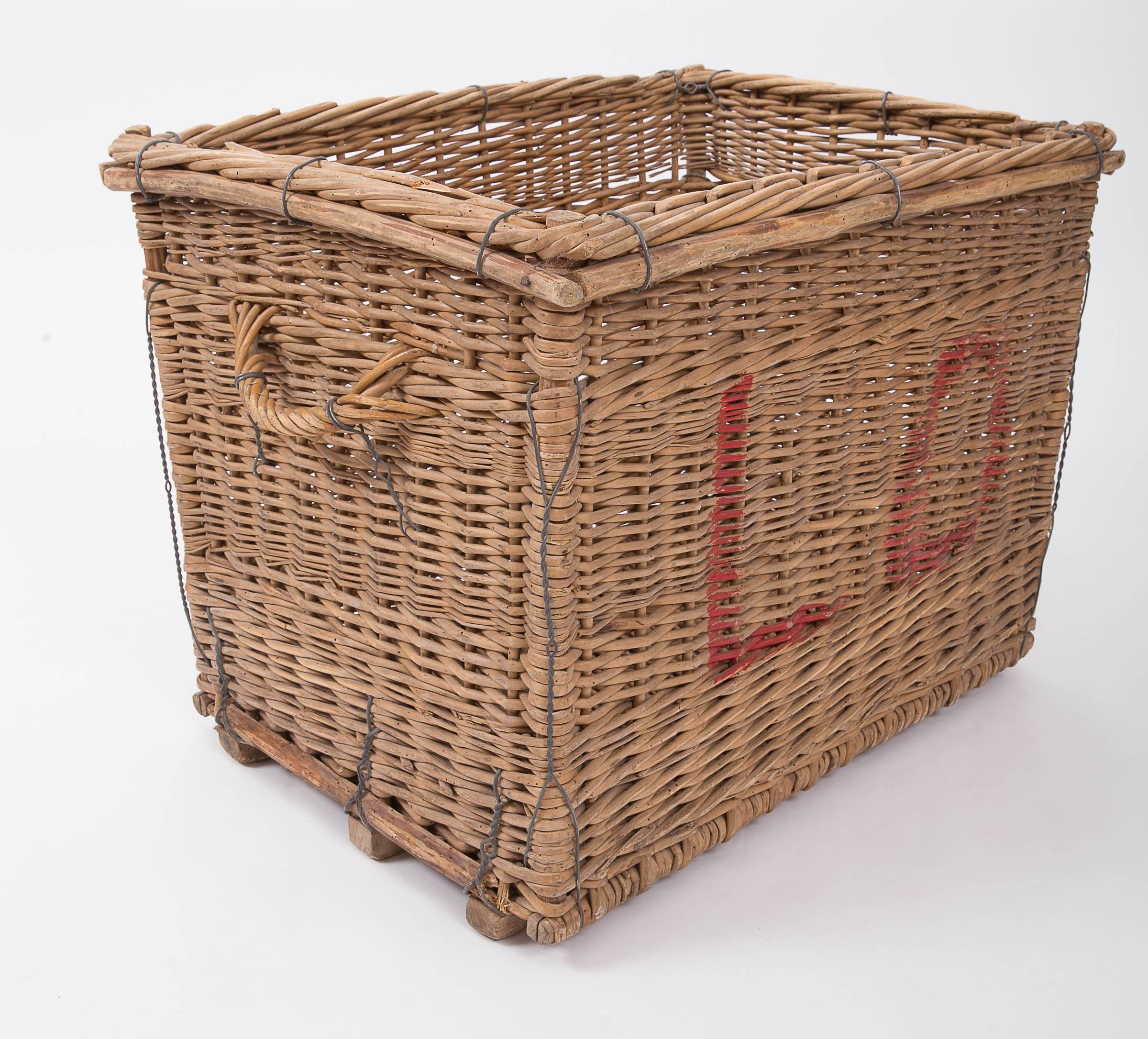 Wicker basket with wooden frame, originally used for carrying champagne bottles from the vineyard, sturdy enough to hold firewood.