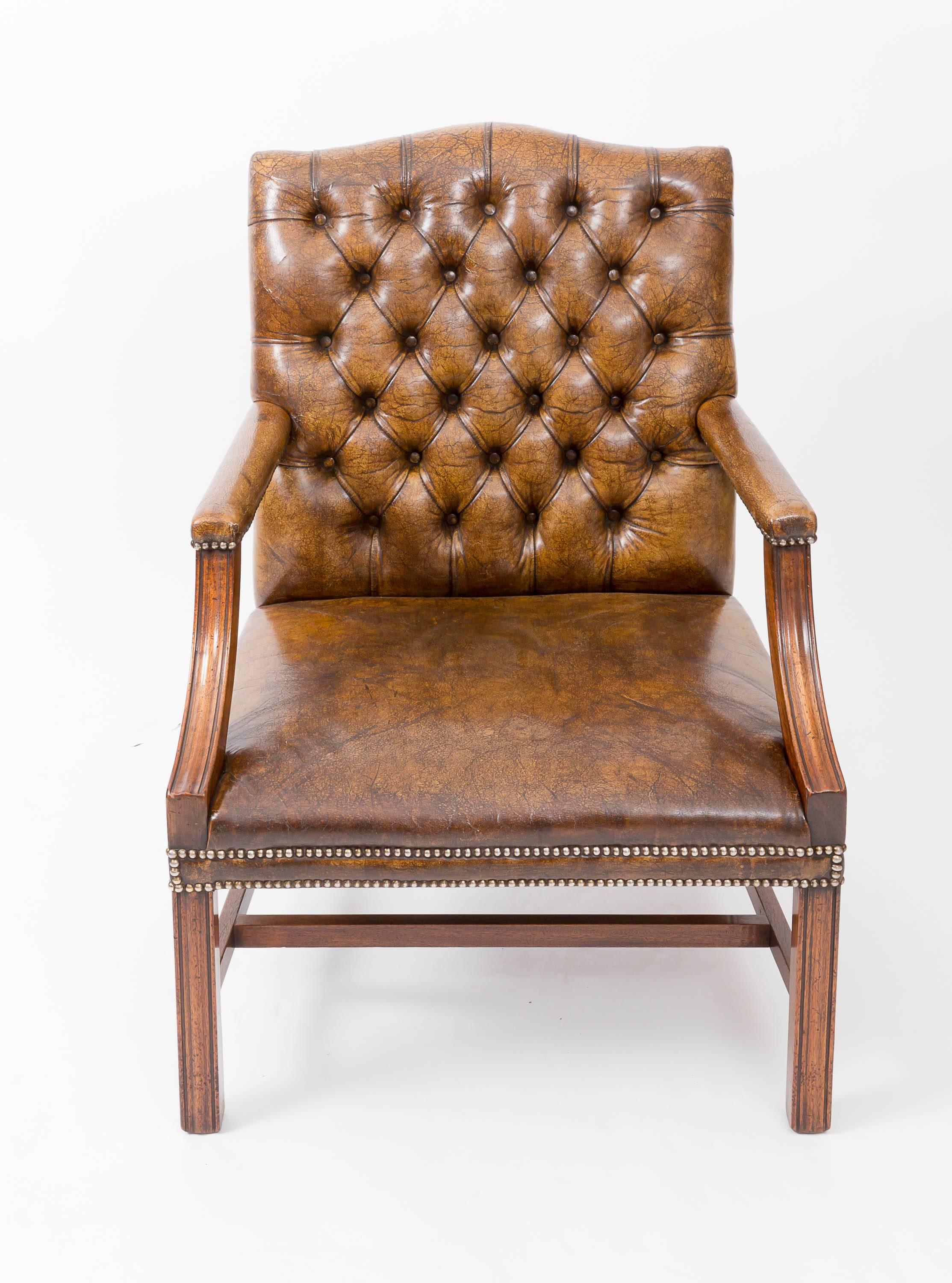 Tobacco leather deep-buttoned back chair with upholstered studded frieze and mahogany stretcher legs.