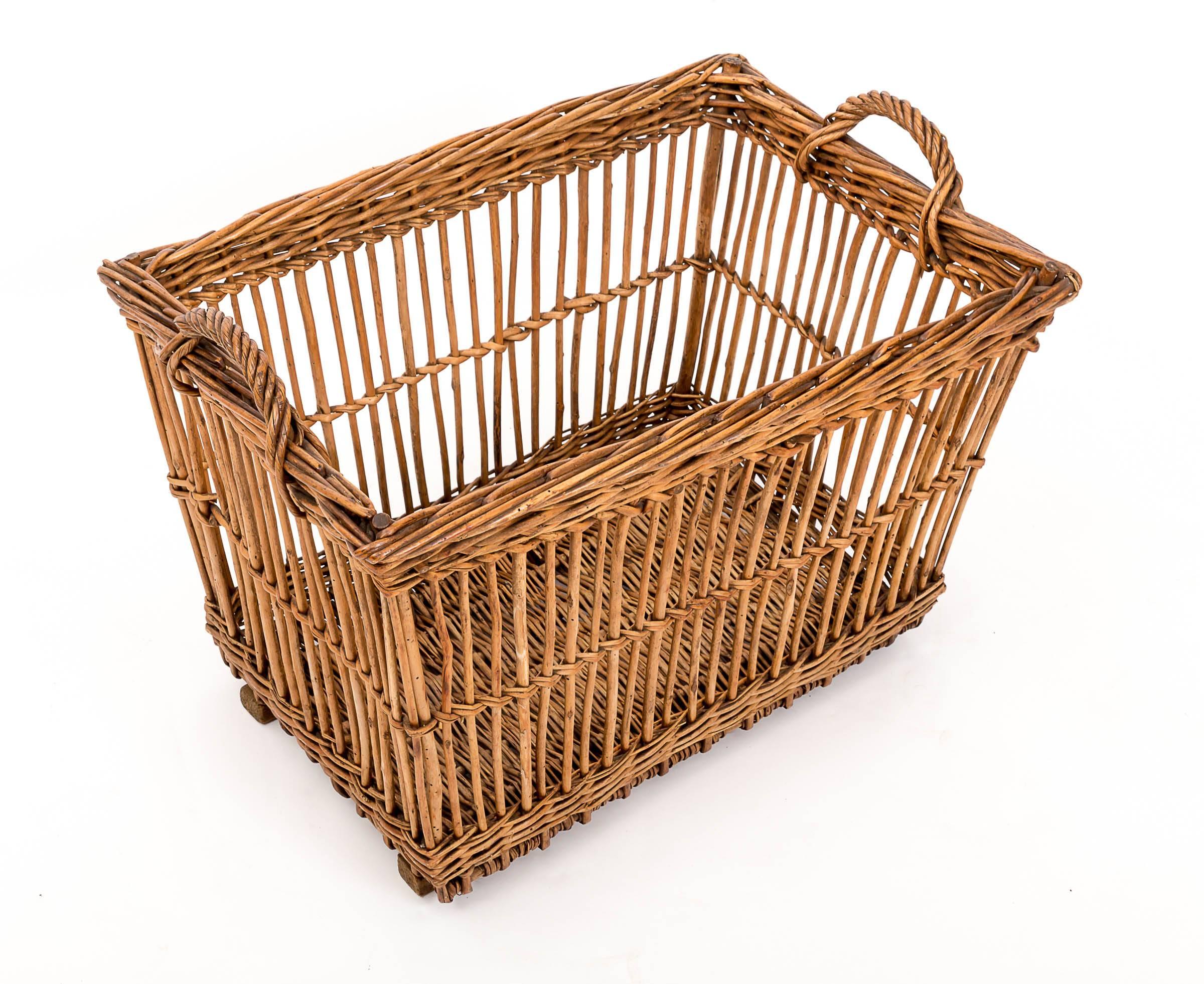 Wicker basket on wooden sledge feet with woven wicker handles, originally used to carry wine bottles. sturdy enough to hold firewood.