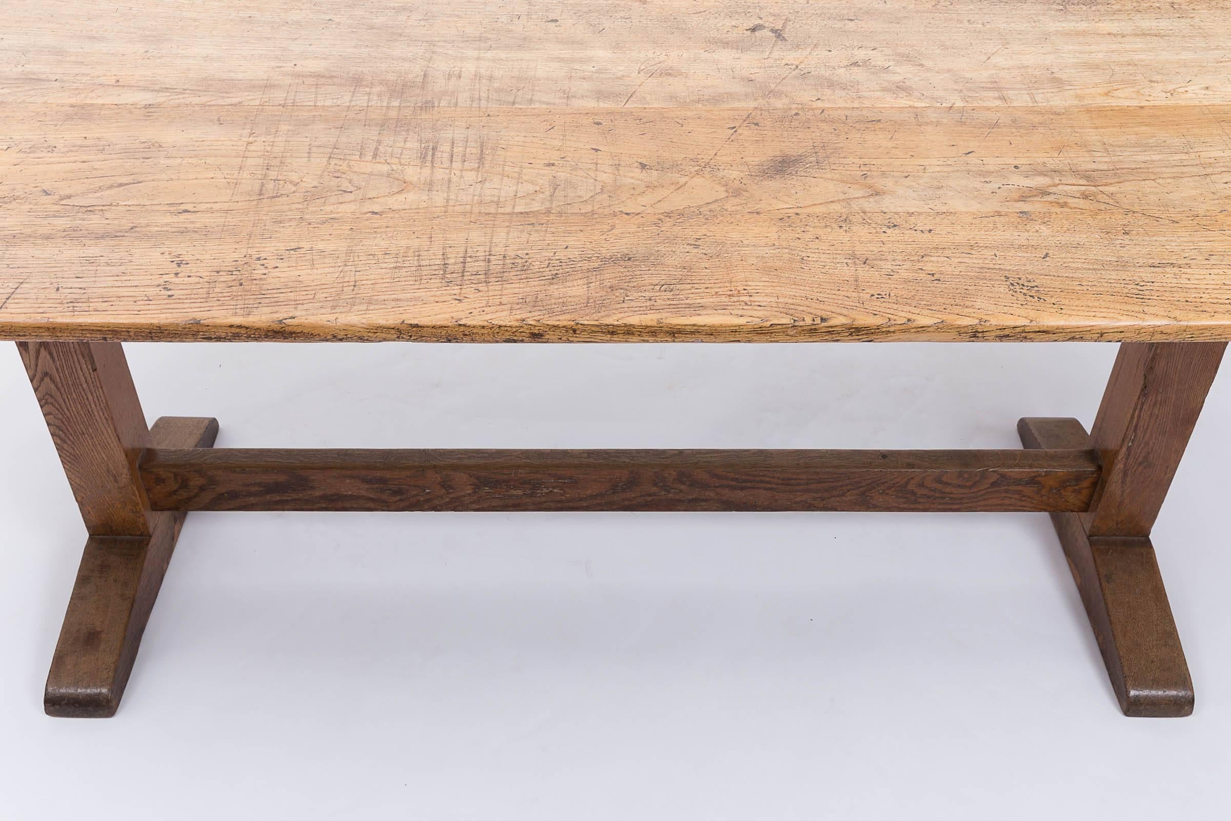 Seven foot trestle dining table with oak top and elm stretcher and legs.
