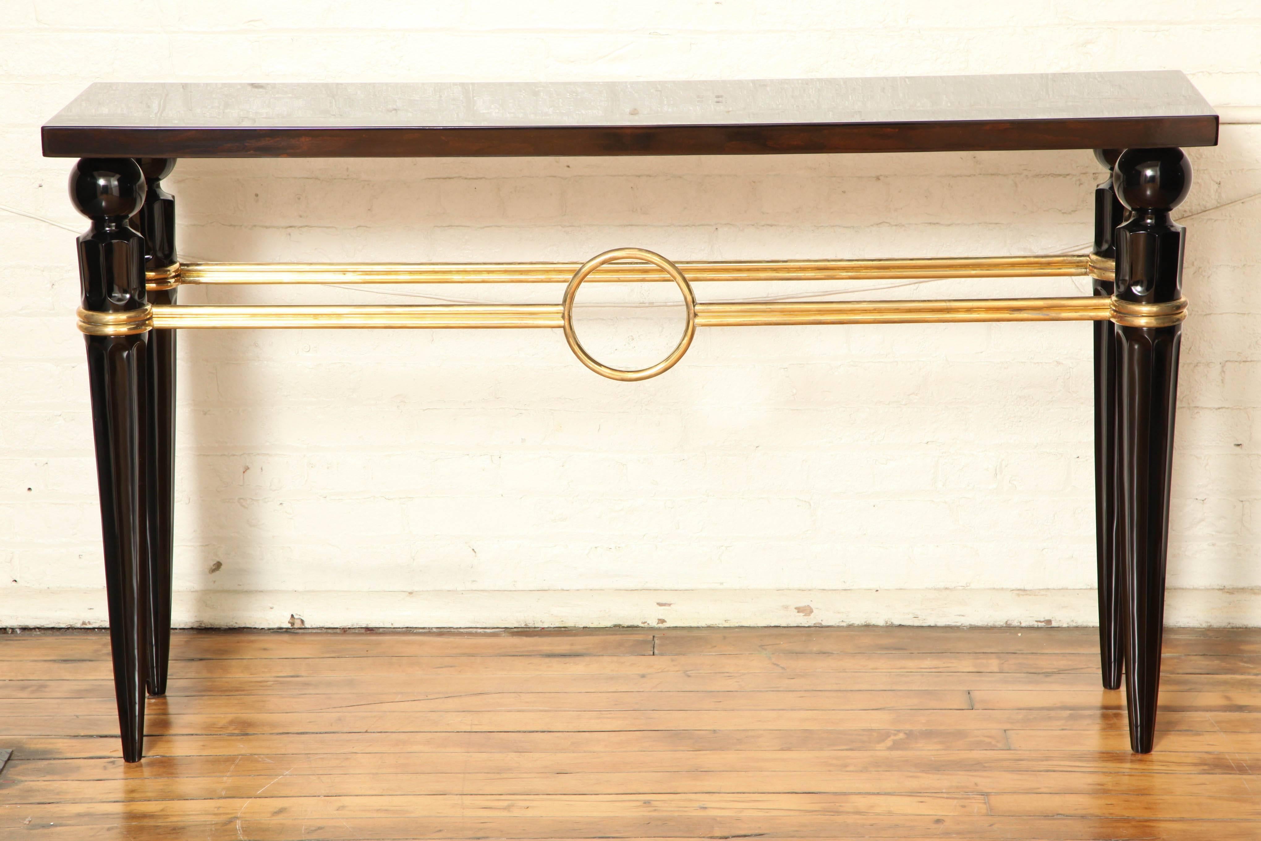 Architectural Art Deco console table. Exotic Macassar ebony with brass stretcher and ebonized wood legs.