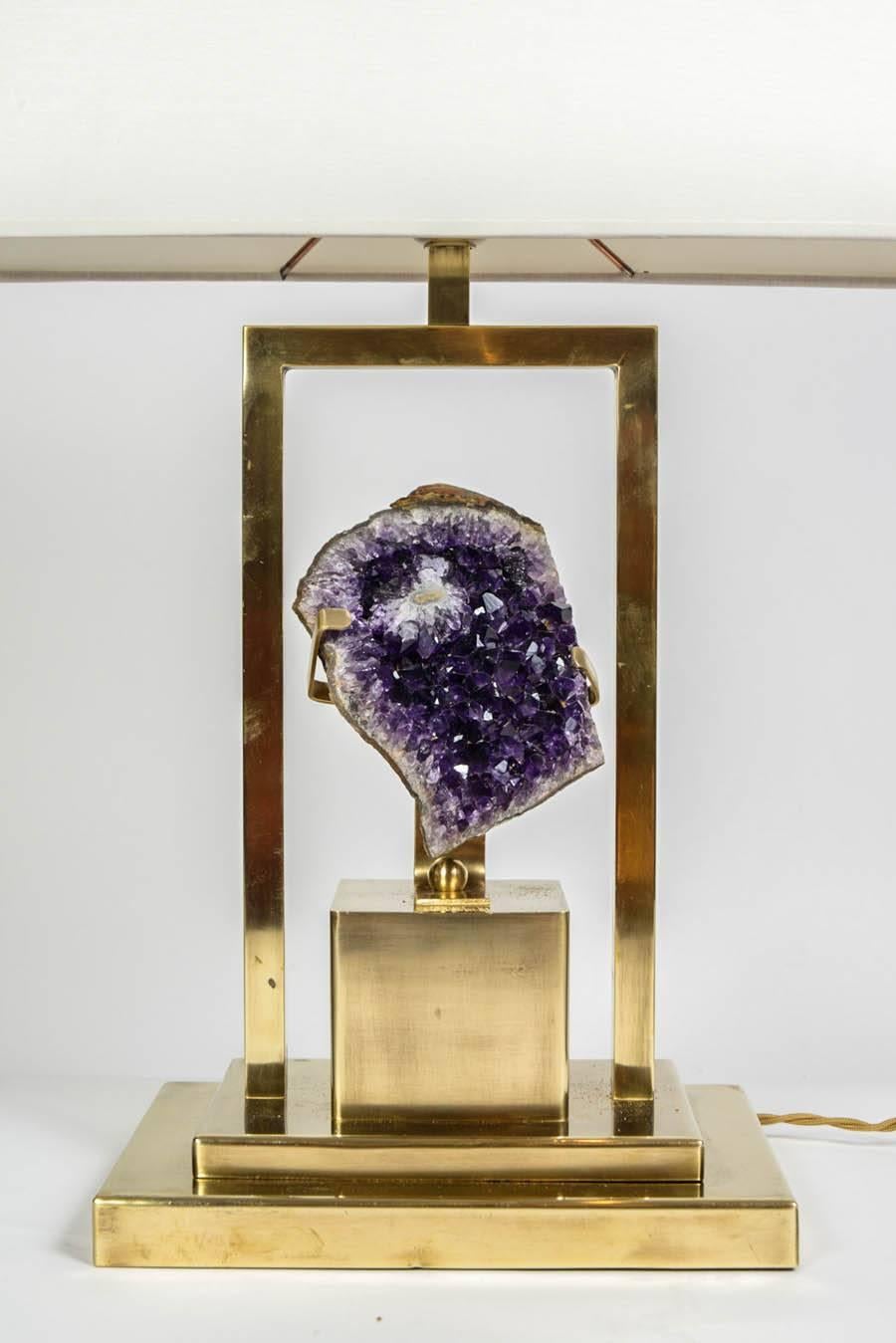 Pair of lamps made of brass feet and setting, displaying two bright amethyst rocks.

New electrification.