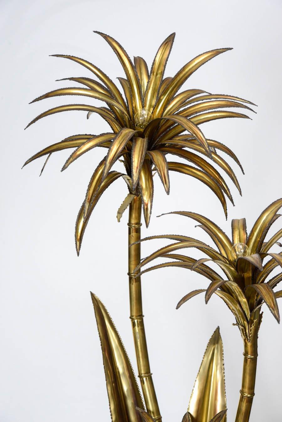 Famous palm trees floor lamp by Maison Jansen. This piece is made of a resin foot and three gilded metal palm trees and big leaves. In the center of the trees is hidden a bulb.
Typical French design from the 1970s, very decorative.