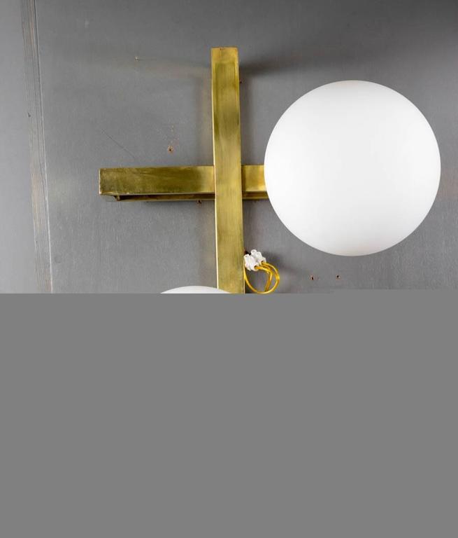 Brass wall sconces made of multiple rectangles assembled and white glass globes. 

 New design by Glustin Luminaires.
