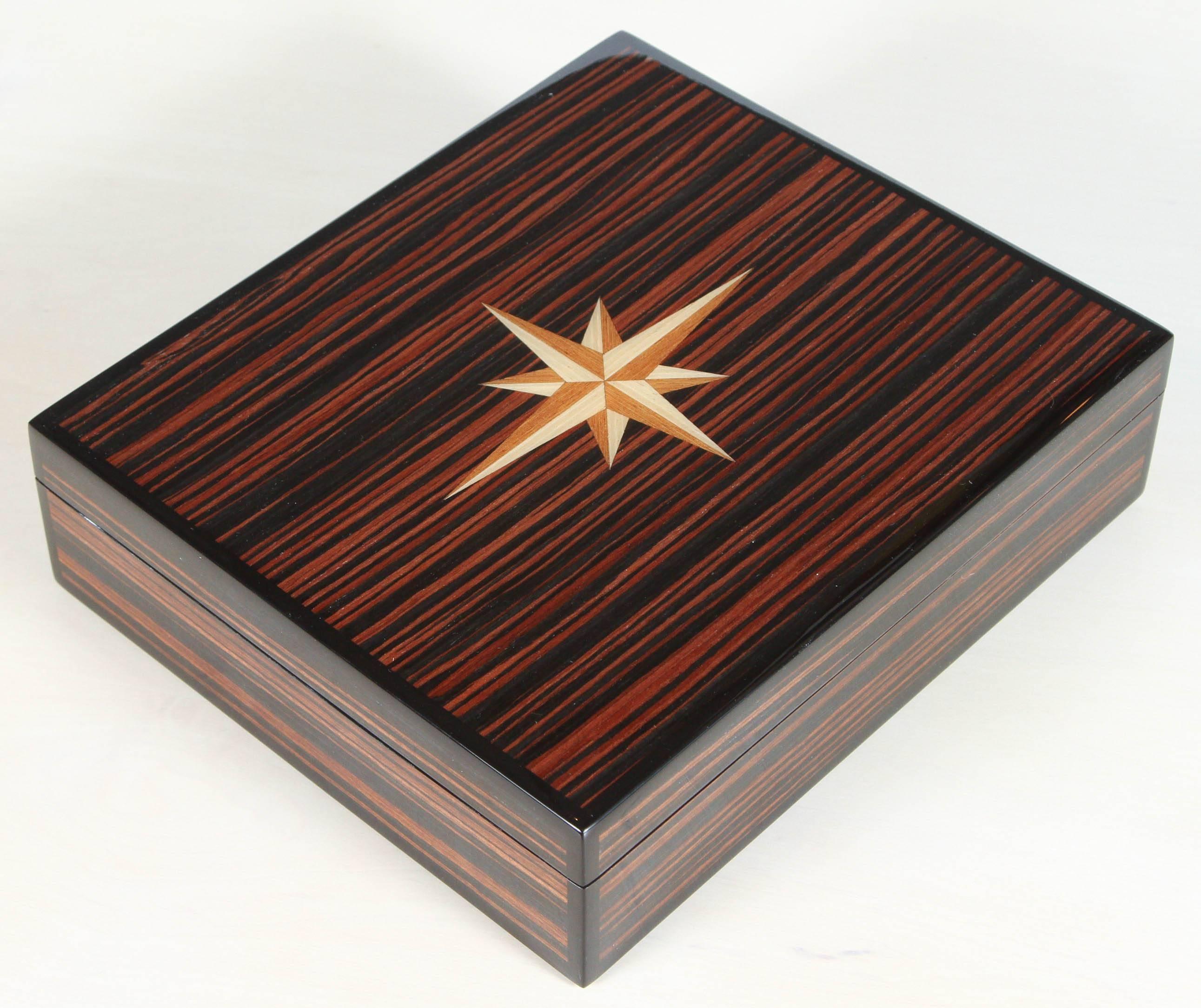 Macassar lidded box with inlay and nine compartments.
