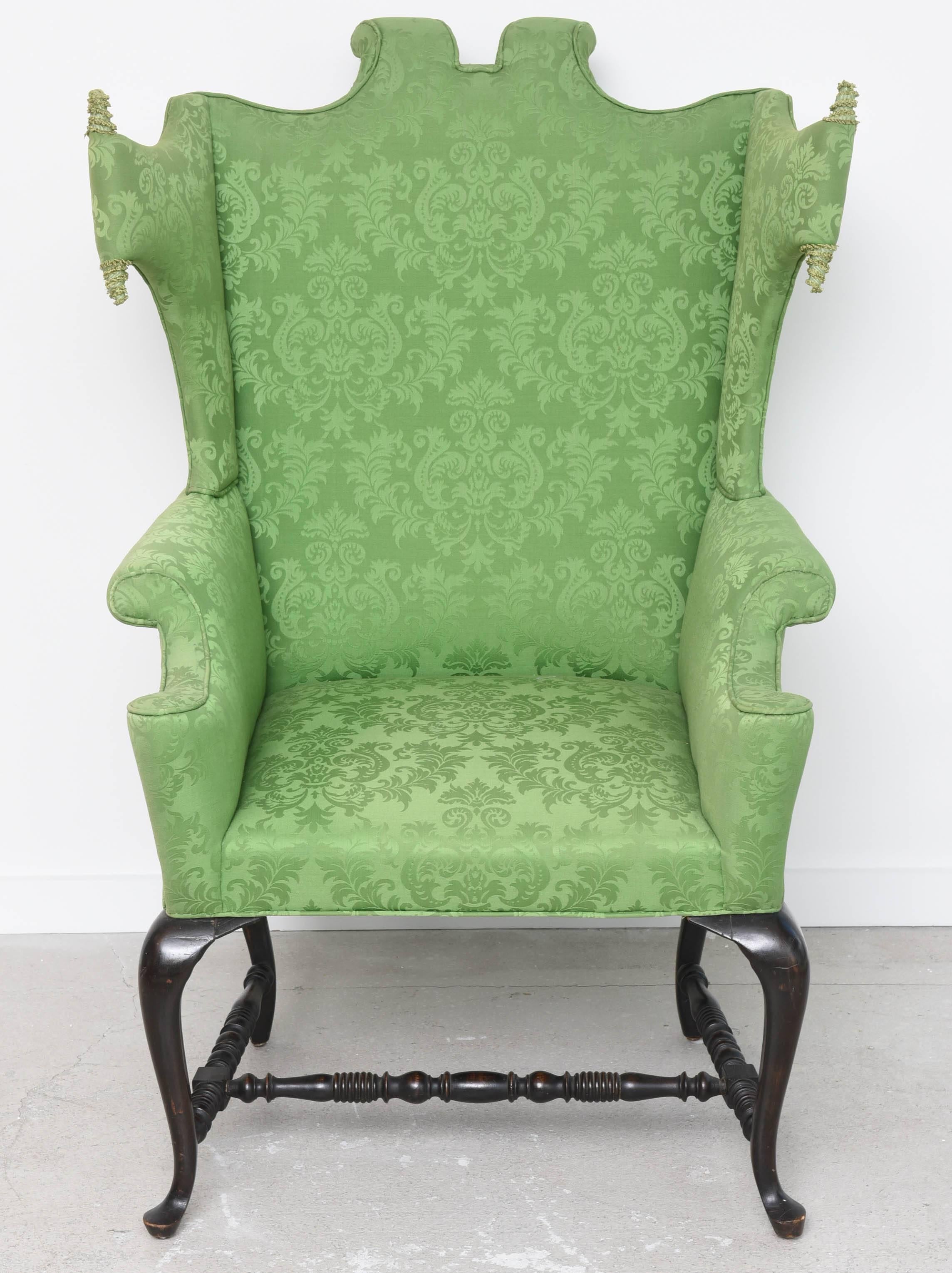Queen Anne style chair with rolled arms, shaped back and stretchers.
The chair is upholstered with green cotton and silk blend damask fabric.