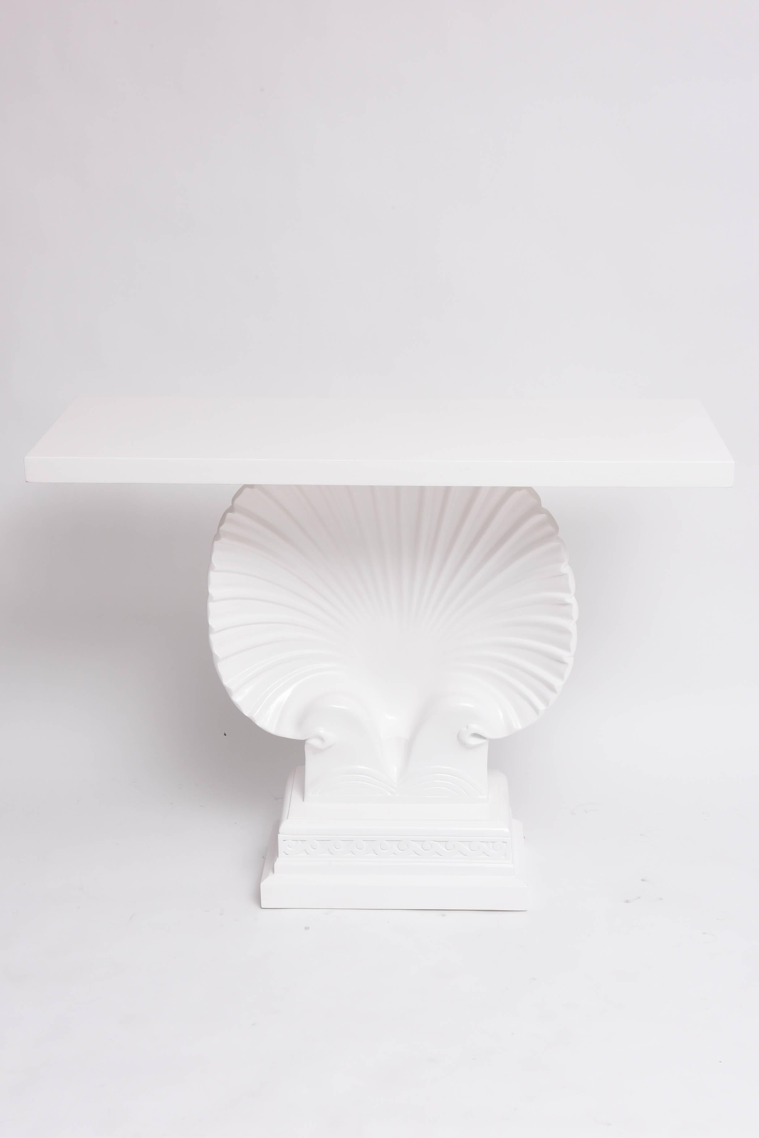 This amazing console table is very much in the Art Deco style and even that of the Hollywood Regency. The piece is of wood and has recently been lacquered in white.

Note: The shell is 24" wide x 24" height.

Please feel free to