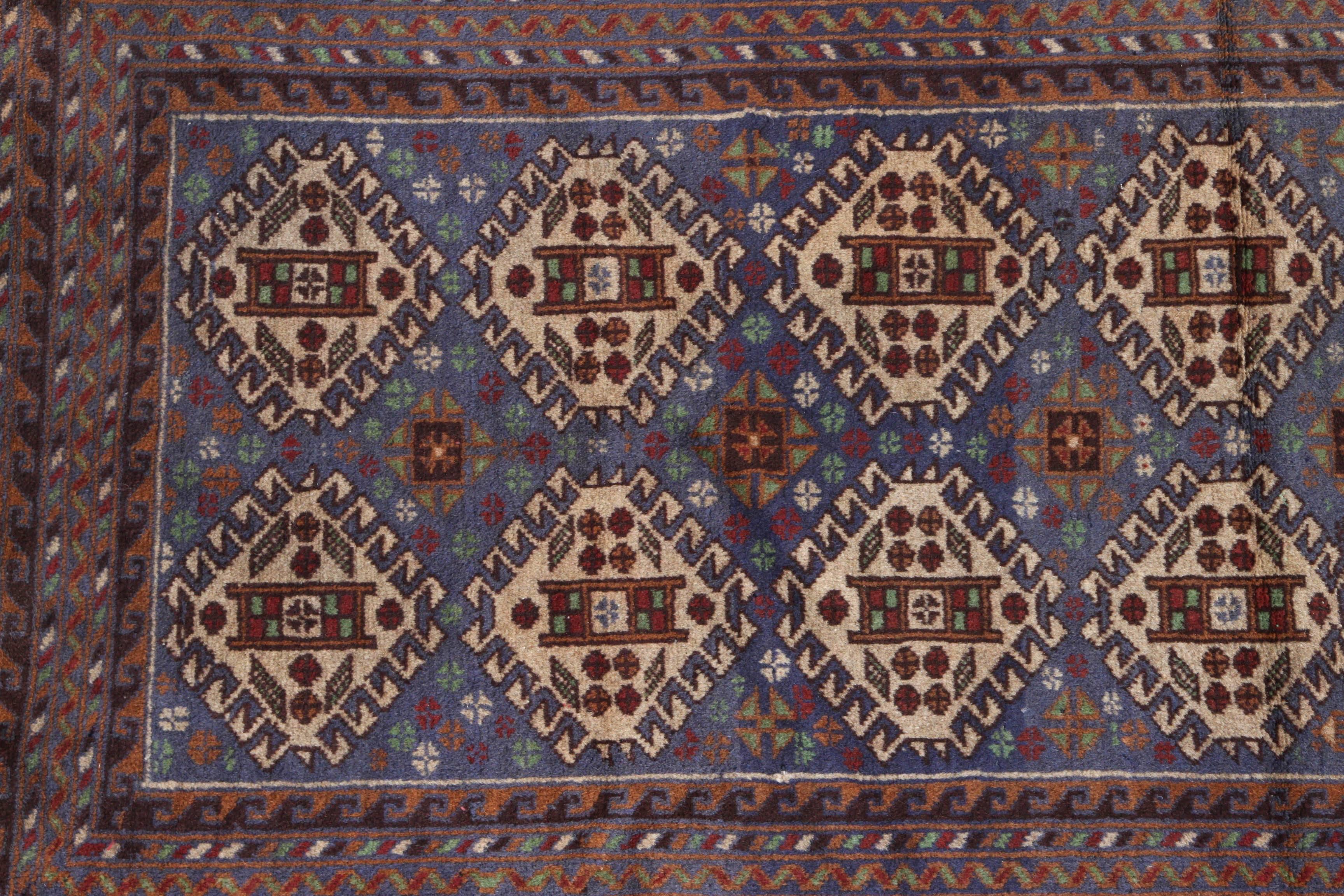 Antique Persian Baluchi rug with multicolored repeating patterns in the center. The outer edge contains rows of repeating wave pattern. Baluchi carpets are handmade carpets originally made by Baluch nomads, living near Iraq, Pakistan and Afghanistan.