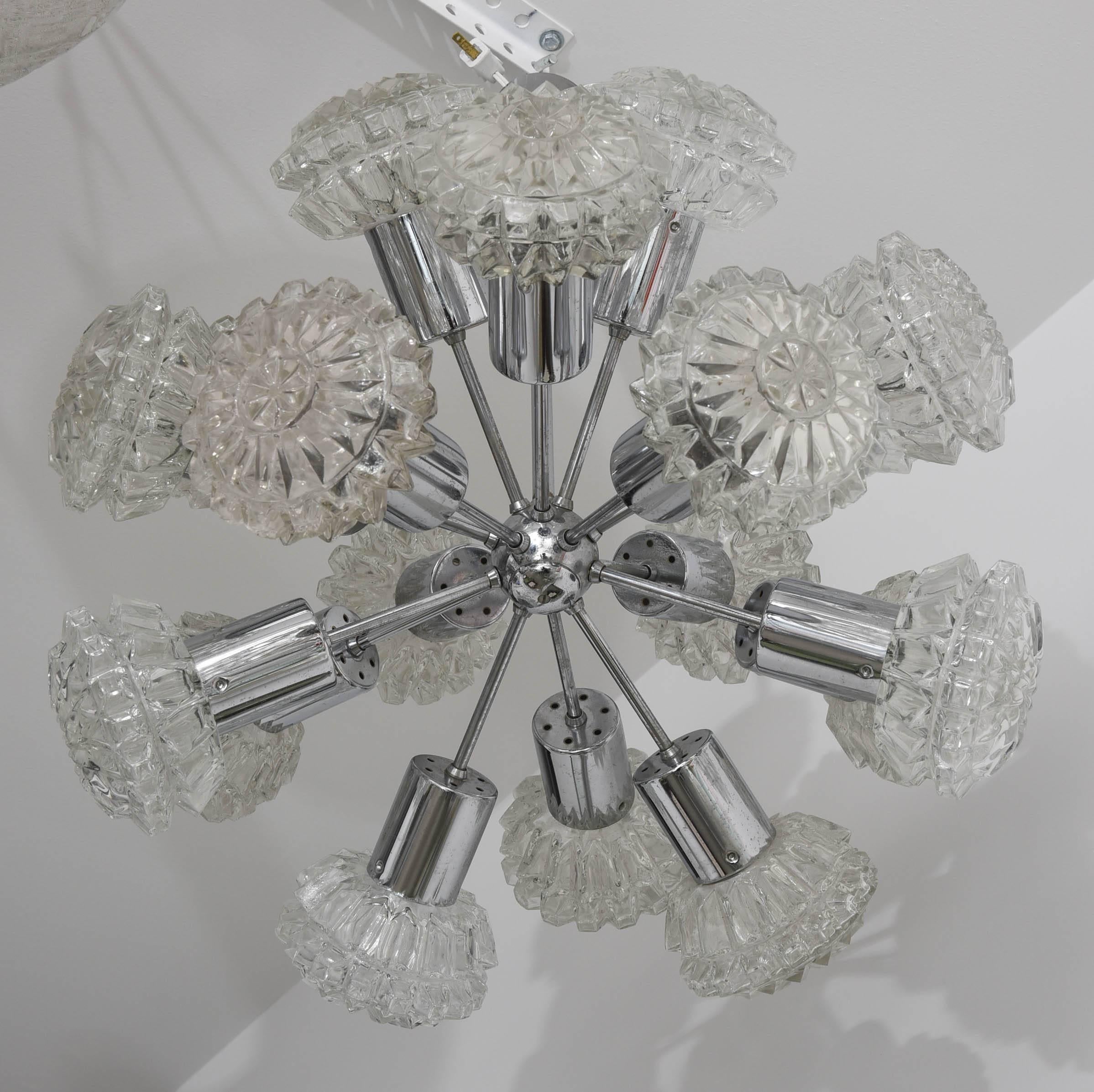 This amazing Mid-Century Modern polished chrome and glass chandelier was created by the iconic designer Richard Essig in the 1960s. The piece is a play on the Classic "Sputnik" with clear glass stylized flowers. 

Note: This piece