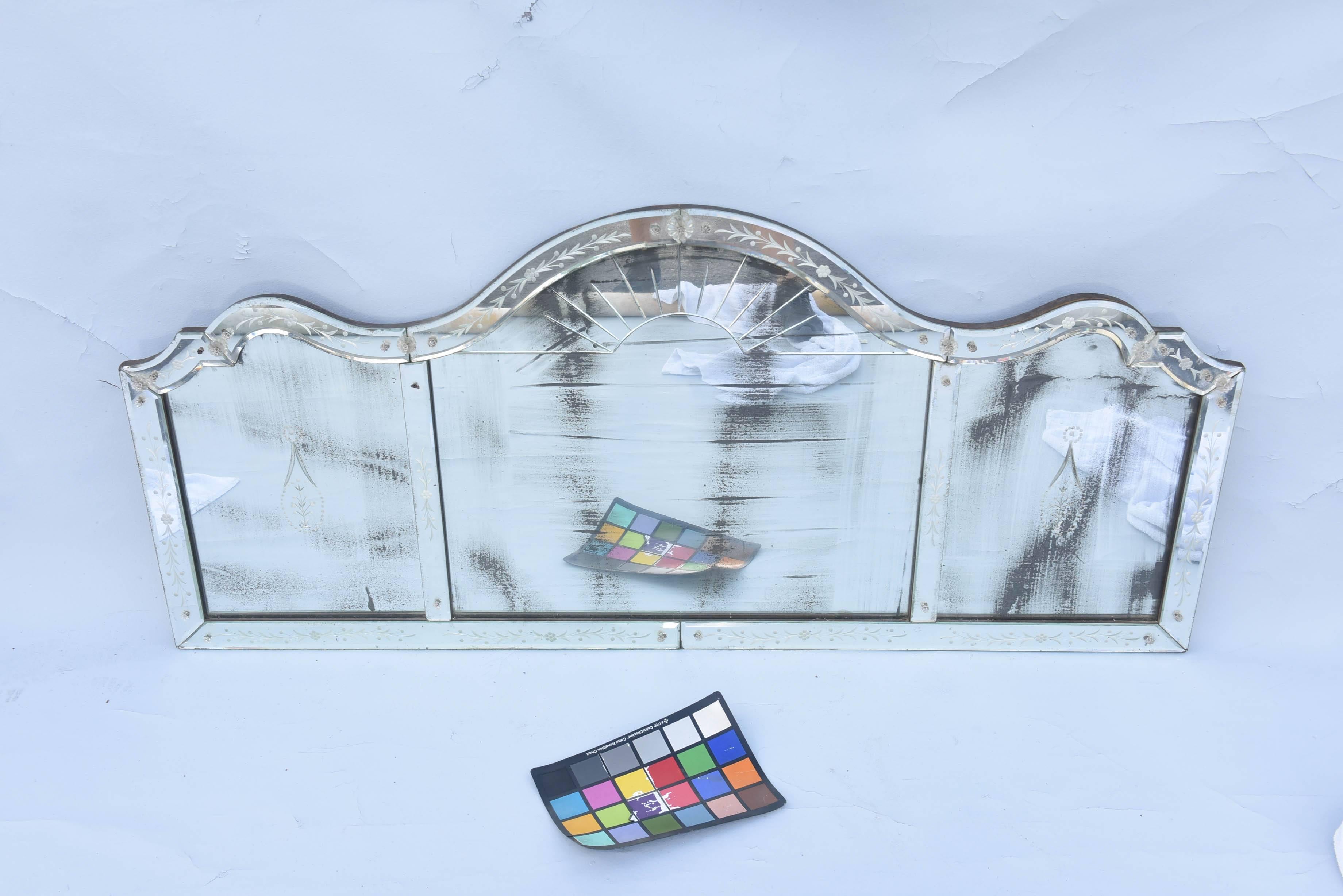 Tripartite overmantel mirror, each panel with natural wear to silvering, its serpentine pediment decorated with foliate decoration, adorned with glass rosettes, each panel with decorative etching.

Stock ID: D8253