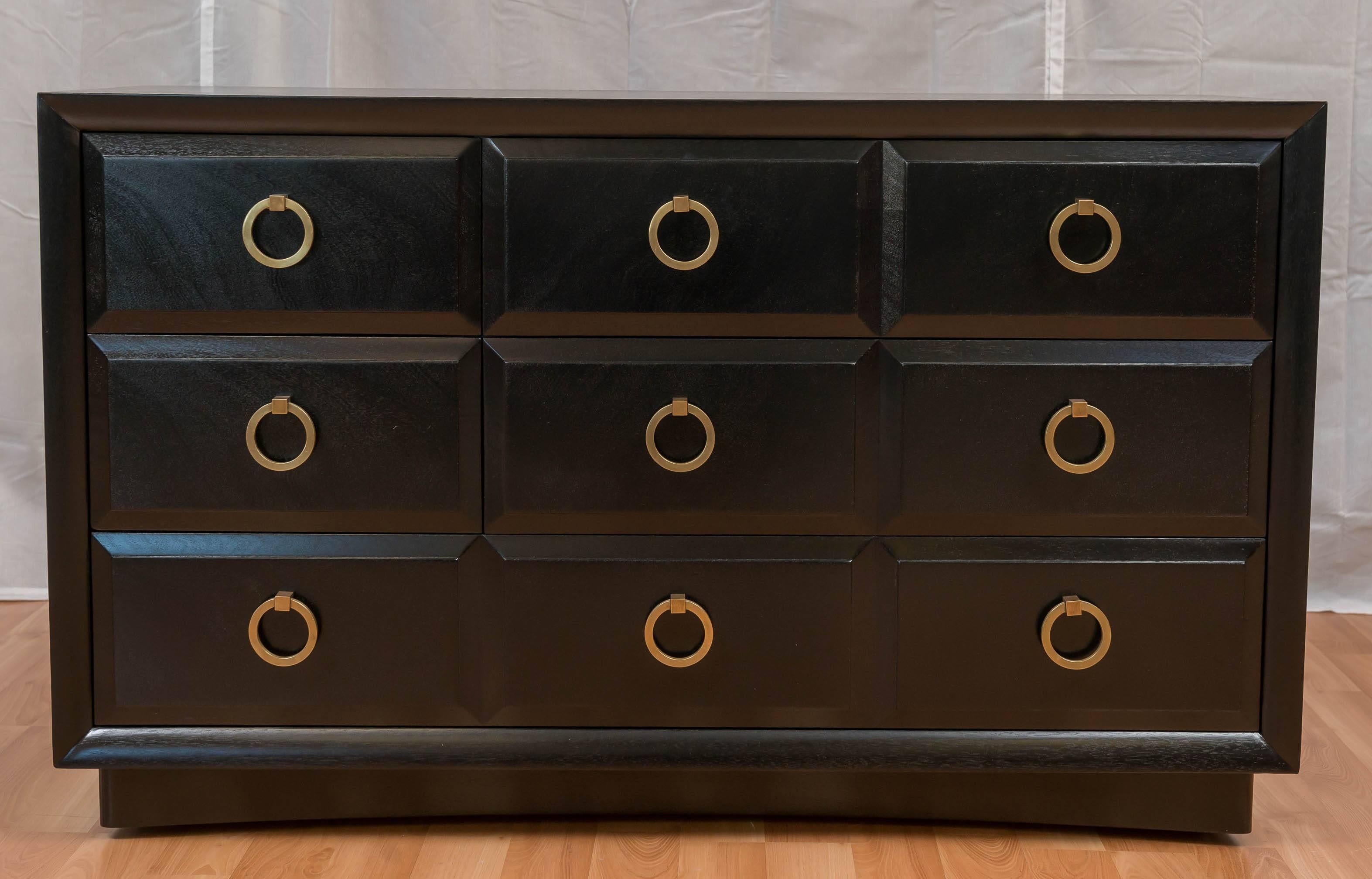 A T.H. Robsjohn-Gibbings Black dresser for Widdicomb, with brass pulls, five drawers, with the large drawer at the bottom, dresser sits on four castors.  We do have another one, on another listing