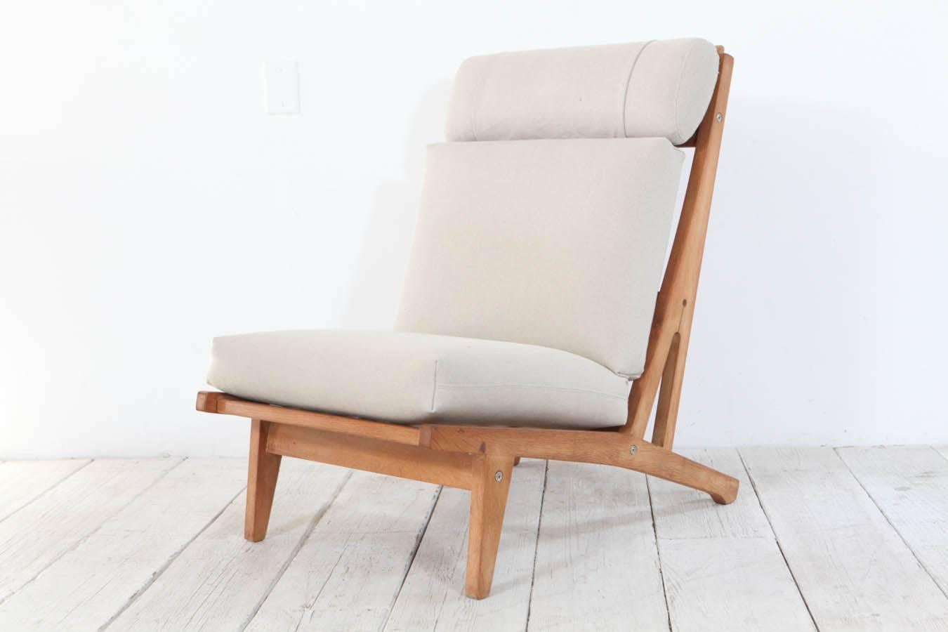 Classic Hans Wegner pair of oak chairs and new linen upholstery. Sold as a pair.
