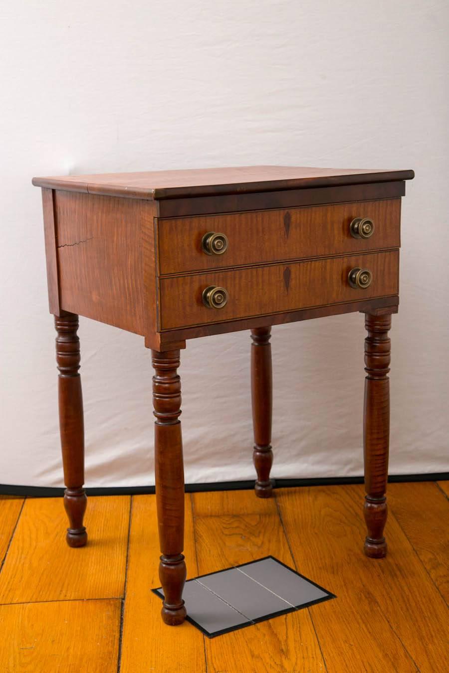 Federal tiger maple two-drawer stand on cylindrical legs with ring turned carvings, New England, circa 1810.

Measures: 29