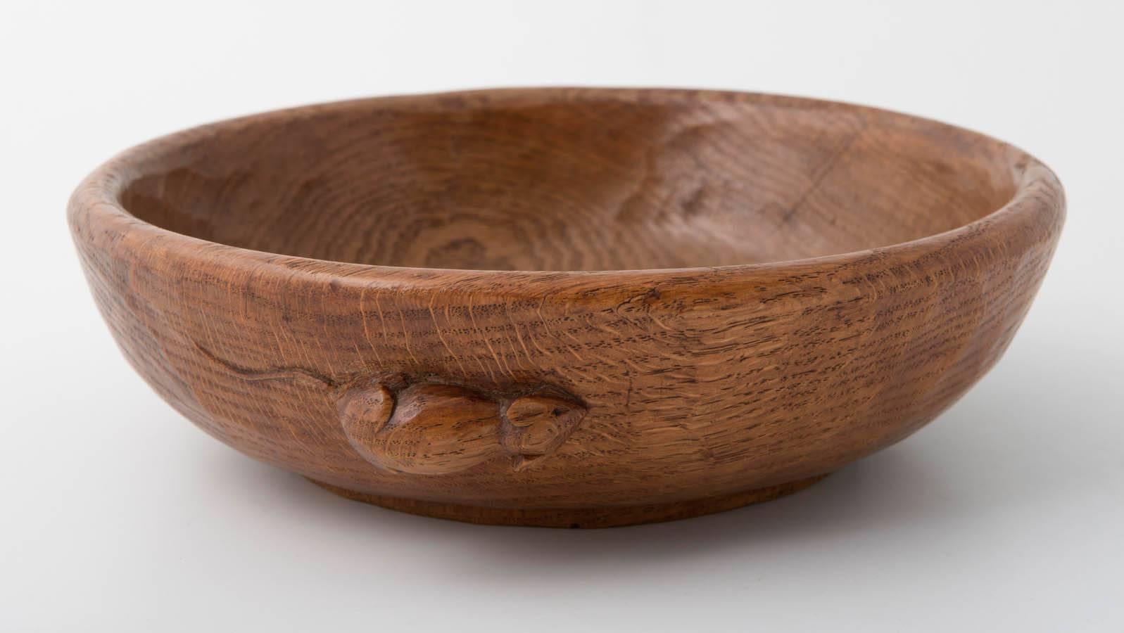A Robert Mouseman Thompson oak fruit bowl.
Adzed all around.
Mouse to side,
English, circa 1960.
Measures: 24.5 cm diameter.
Crack.
 
