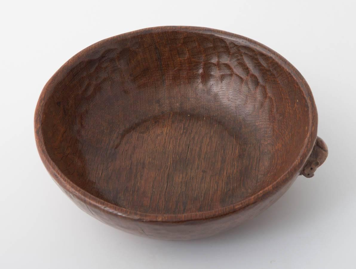 A Robert Mouseman Thompson oak bowl.
Adzed all around.
Mouse to side,
English, circa 1950.
23.5 cm diameter.
   