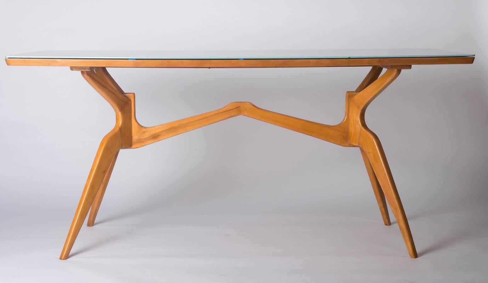An Italian beech centre table in the style of Franco Campo & Carlo Graffi. The splayed spider legs supporting a rectangular shaped top with modern colored glass, Italy, circa 1950. Measures: 78 H x 170 W x 81 cm D.