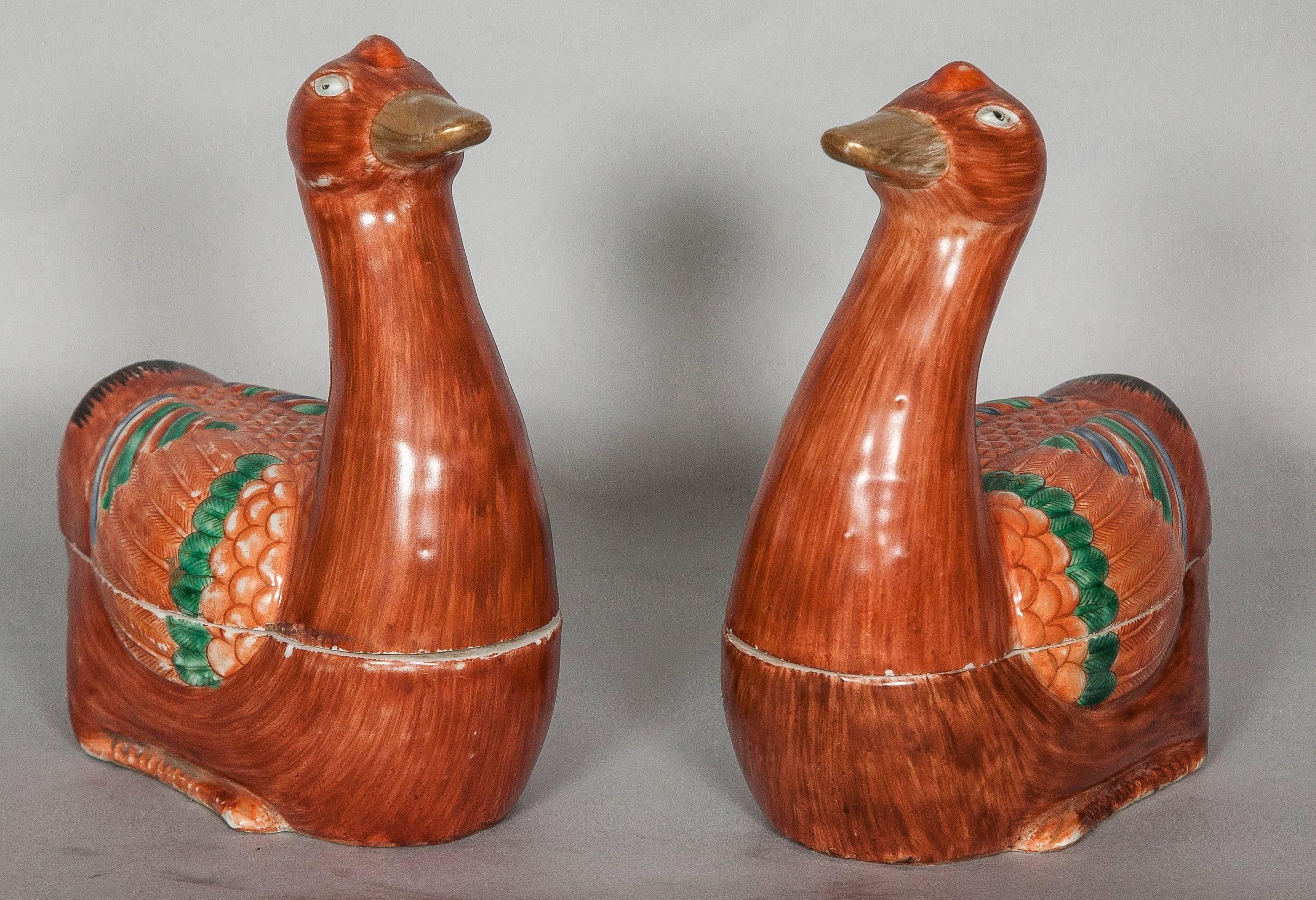 A decorative and colorful pair of mid 19th century Chinese tureens each modelled in the form of a recumbent goose with legs tucked underneath its body and head looking forward, the body pencilled with iron-red feathers, the wings brightly enamelled