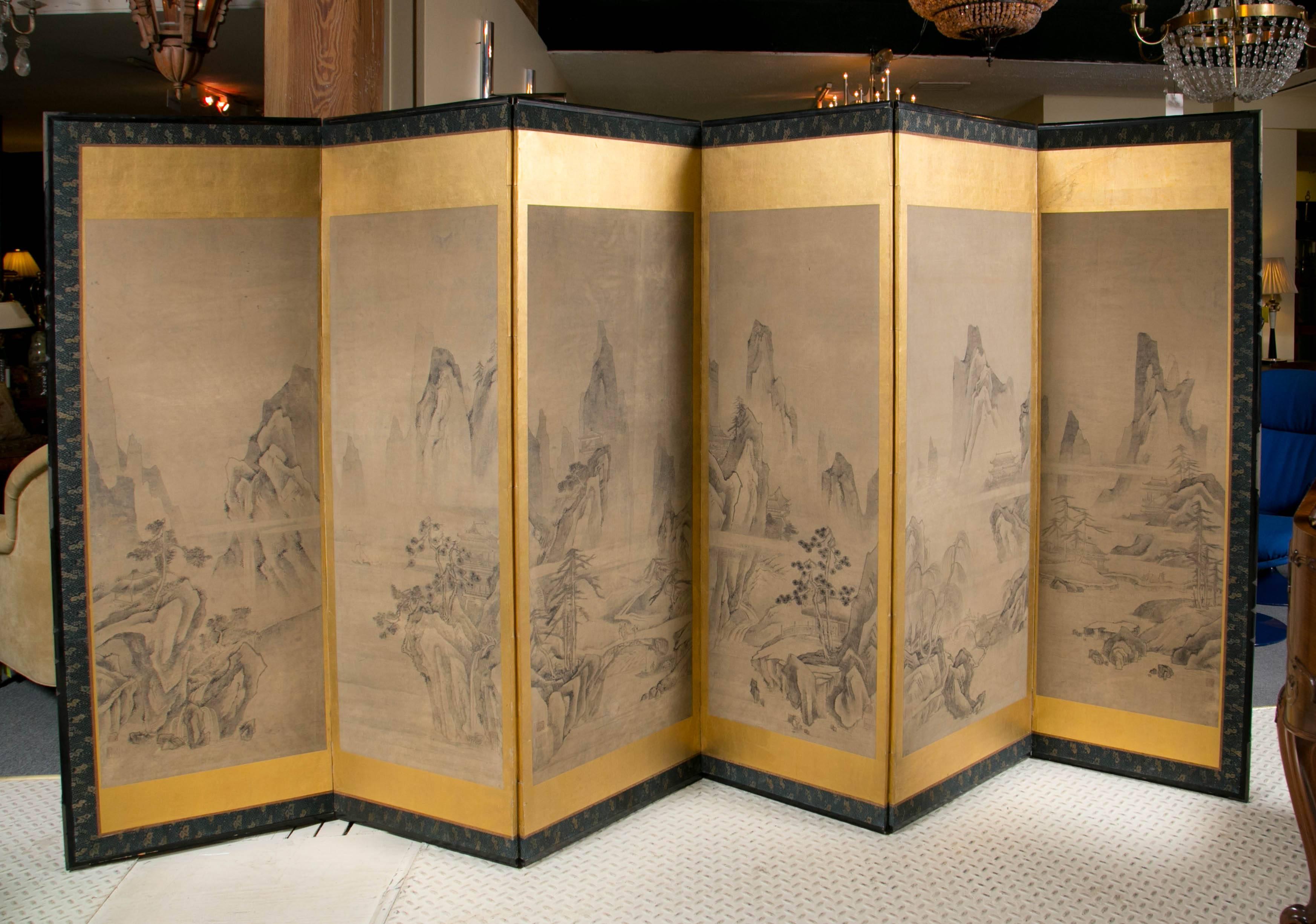 Late 19th Century Japanese folding screen, ink on paper depicting a mountain scape.
Mounted on gold leaf with silk brocade border.