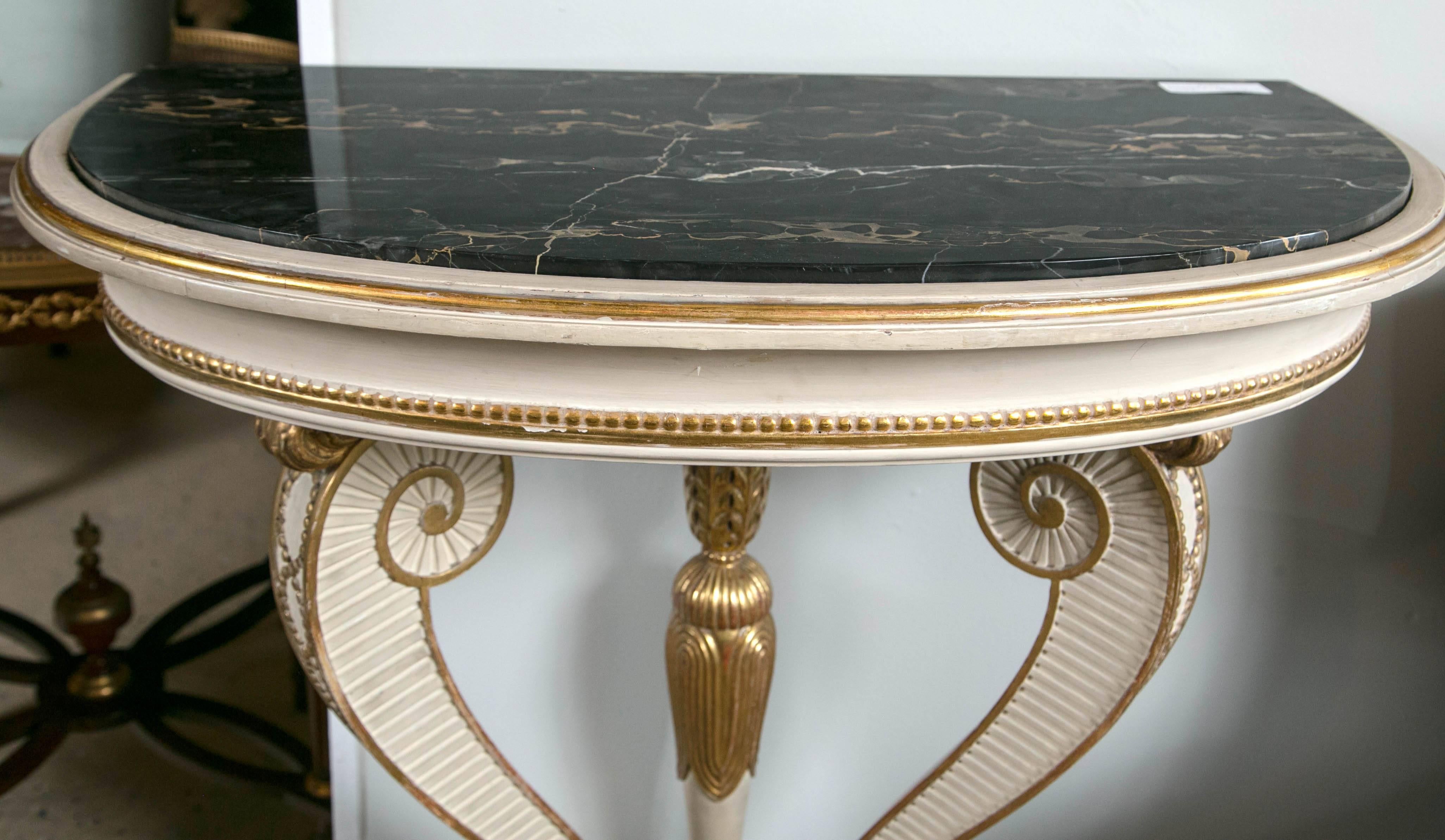 Maison Jansen marble-top paint and parcel gilt demilune console. Exquisite and fine design by Maison Jansen with Lion's Paw feet sitting on a crème painted base. The center base is beautifully detailed highlighting a gilded center tassel leading
