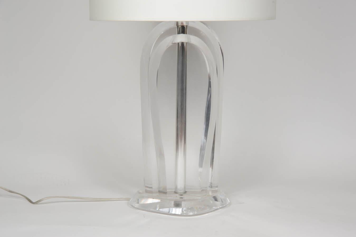 Chic pair of lamps entirely made of Lucite, with a shiny metal stem in the middle supporting the hardware and hiding the wire.