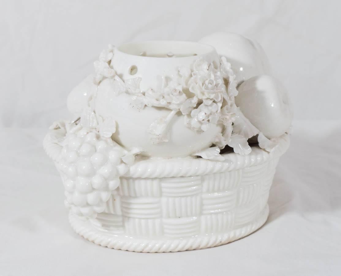 An early 18th century soft-paste porcelain St. Cloud Potpourri jar. The potpourri jar is molded in a pierced oviform. The vase encrusted with flowering branches surrounded by peaches, grapes, apple, pomegranate and fig in an oval basket (see image