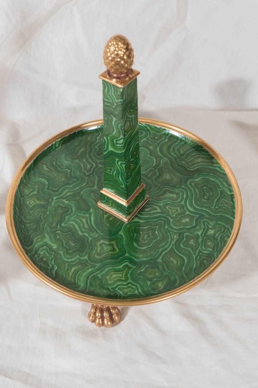  An extraordinary faux malachite pedestal with a set of six egg cups. The  tromp l'oeil porcelain stand mimics perfectly the rich patterned greens of malachite. The base supports an obelisk surmounted by a gilded pineapple finial. The egg cup