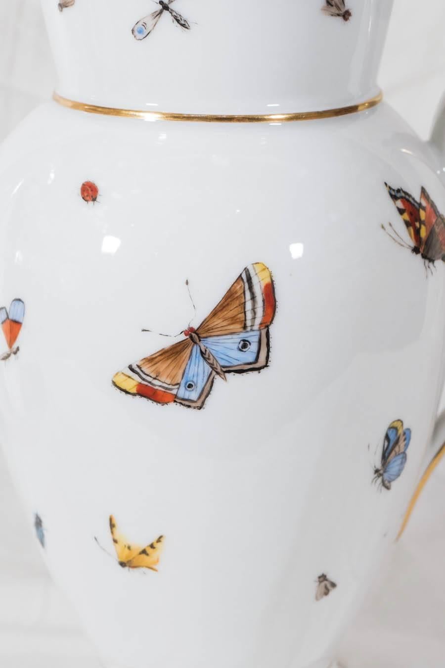A large Vieux Paris decorative coffee pot painted with a variety of colorful insects on crisp white porcelain. The insects include: Numerous butterflies, dragonflies and lady bugs. The spout in the form of a long necked bird.
 