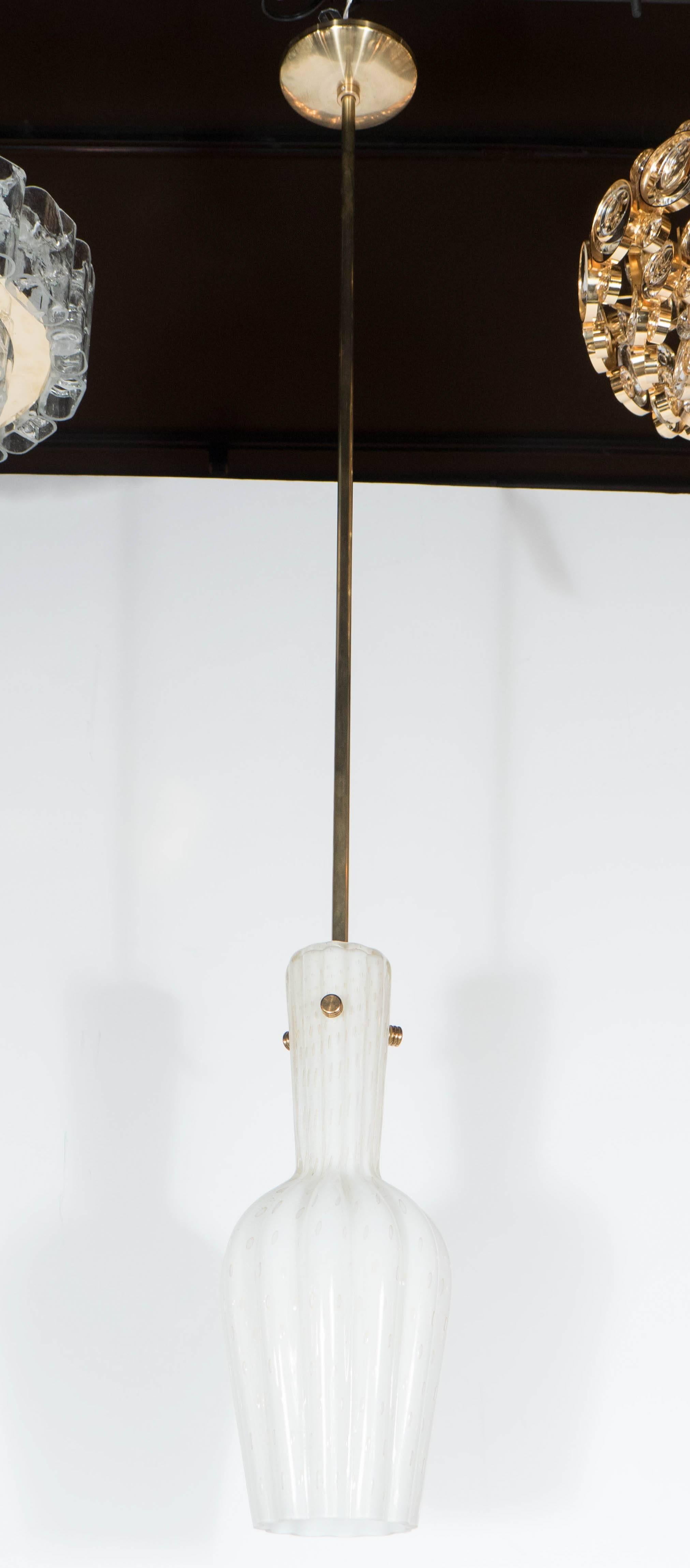 This stunning pair of textured and layered white and clear glass pendants were realized in the manner of Avem in Italy circa 1950. Murines with 24-Karat gold flecks adorn each pendant and are supported by antiqued brass fittings. With their clean