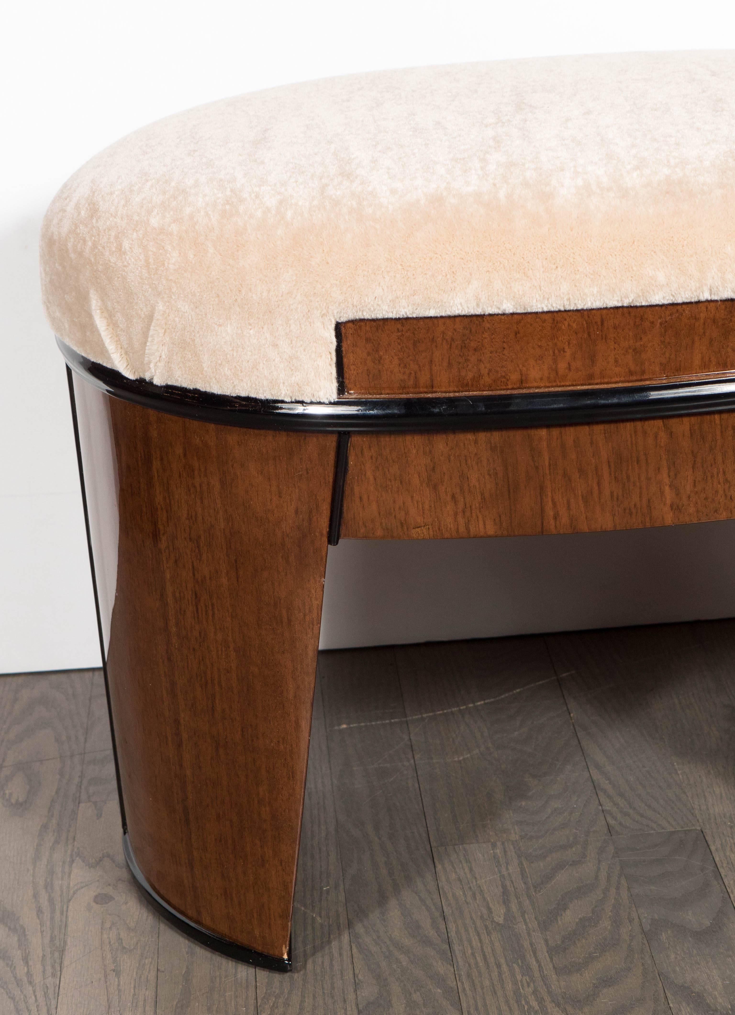 This exceptional Art Deco skyscraper style stool features a streamlined ovoid design with a tapered cut-out style leg in bookmatched walnut with a black lacquer trim and new camel mohair upholstery. Restored to mint condition.