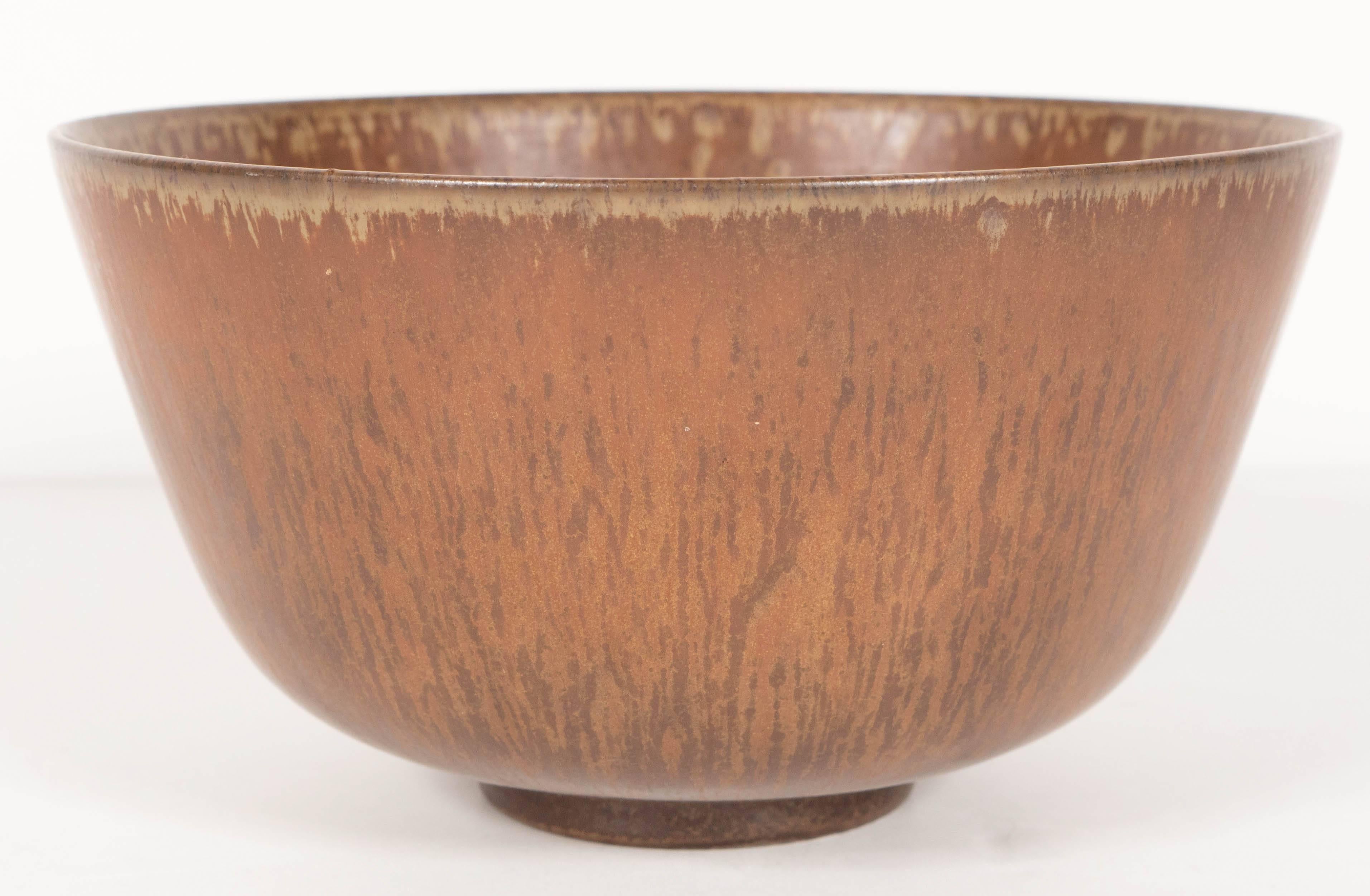 A handsome Mid-Century Modernist ceramic bowl by Gunnar Nylund for Rörstrand. An abstract pattern with hues of brown and matted finish give this piece a very organic feel. Signed on its bottom. This piece is in excellent condition.