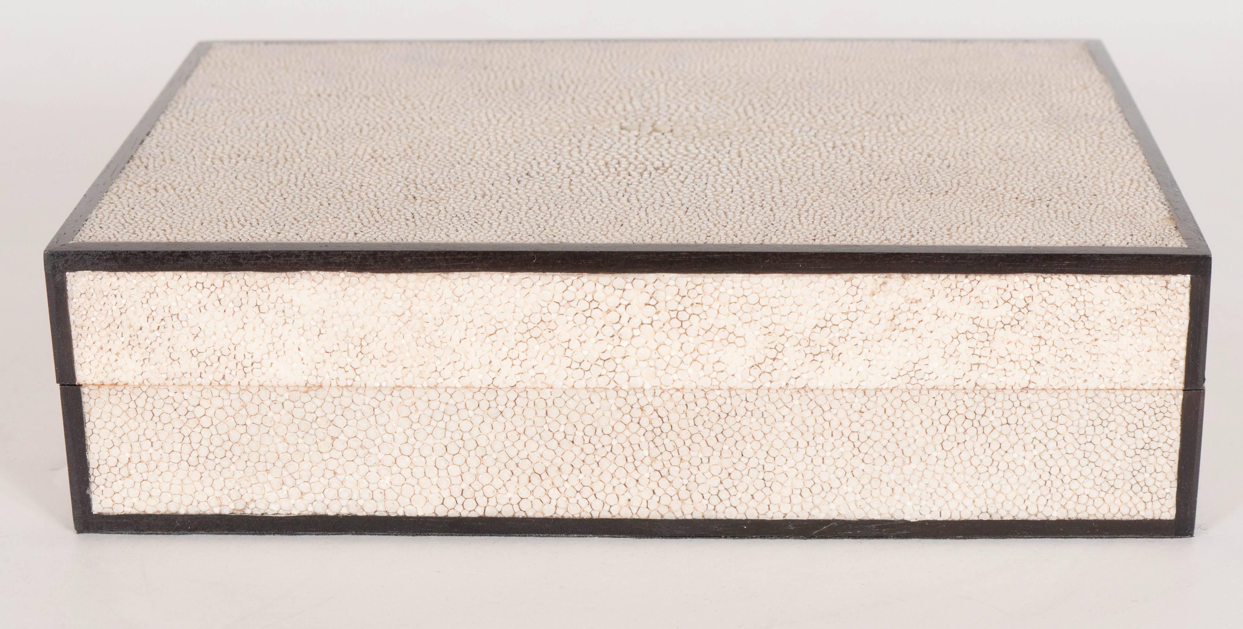 A very chic box fully wrapped in ivory-dyed shagreen, with a removable lid, with a jet-black wood trim along its perimeter. The inside is lined with lacquered oak. A perfect addition to any cocktail table vanity, console or shelf. This piece is in