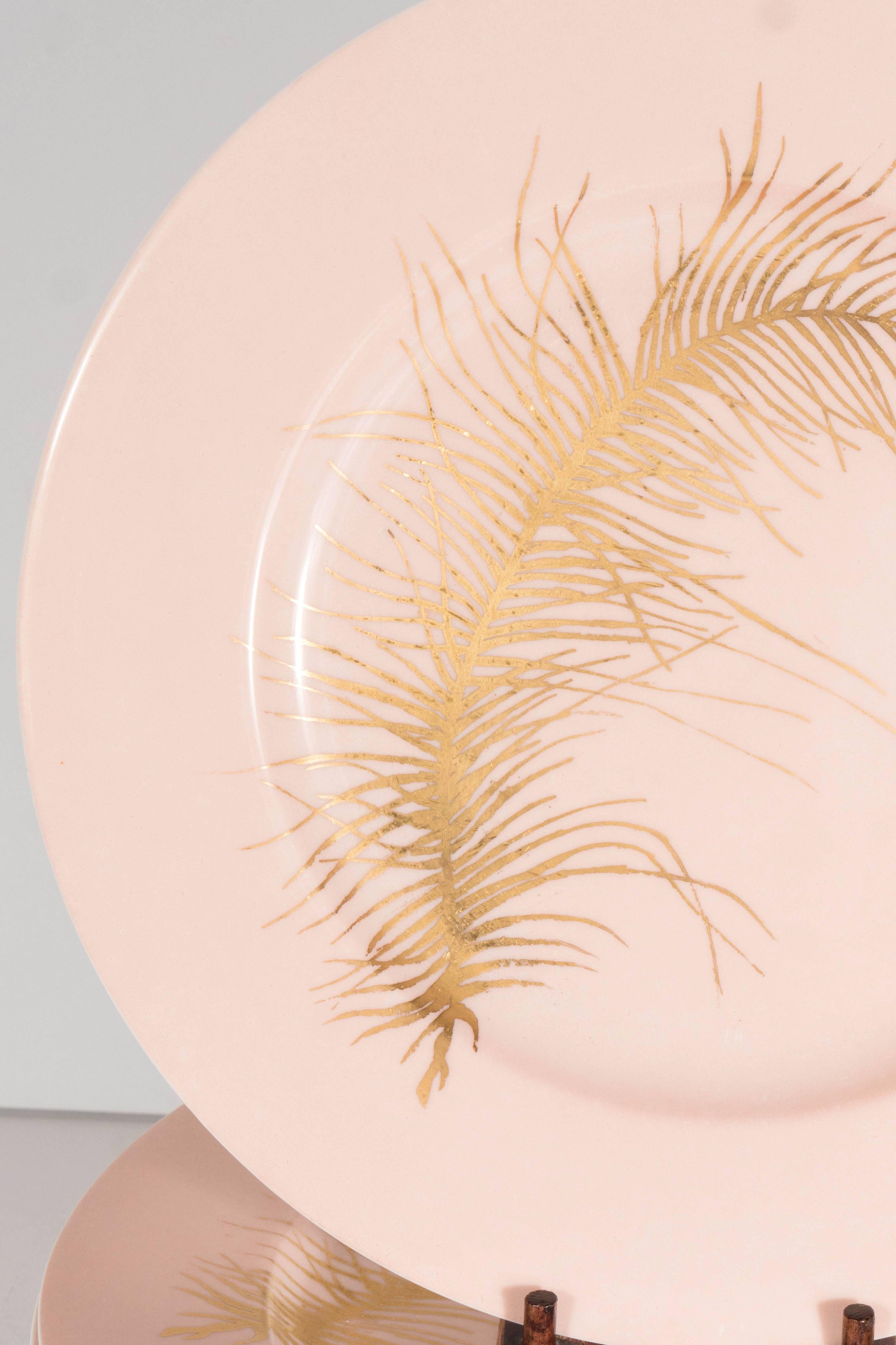 A beautiful set of eight dinner plates in pink with 24-Karat yellow gold feather or leaf detailing. Each piece featured a single feather or leaf depicted in wonderful detail. The matted salmon finish on the plate contrasts wonderfully with the gold