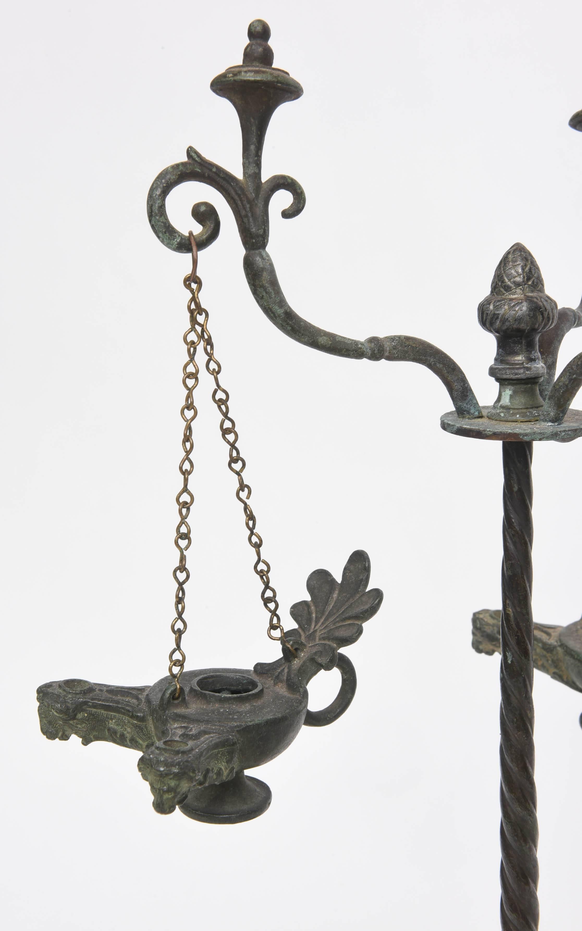 Patinated bronze tripod oil candelabrum with 3 small oil lamps hanging on chains.  The tripod has satyrs' legs with hooved feet, ibis birds, palmettes, a torqued central column, foliate arms and finials.  Italian, 19th century.   Beautiful verdigris