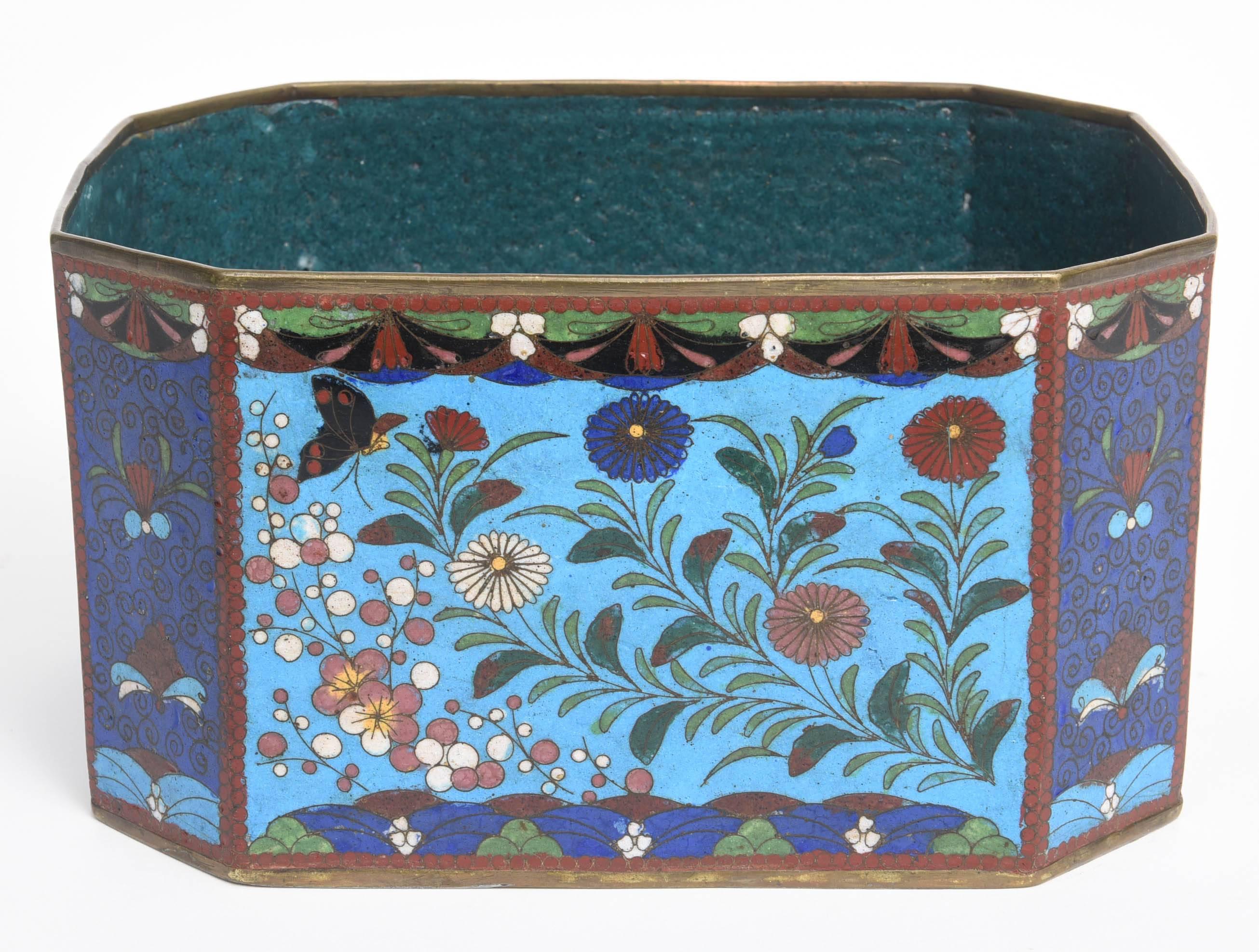 This highly attractive Chinese cloisonné box is decorated with peonies, chrysanthemums, lilies, a bluebird and butterfly.  It would make an excellent cachepot or container for other decorative objects.  Unusual octagonal form.